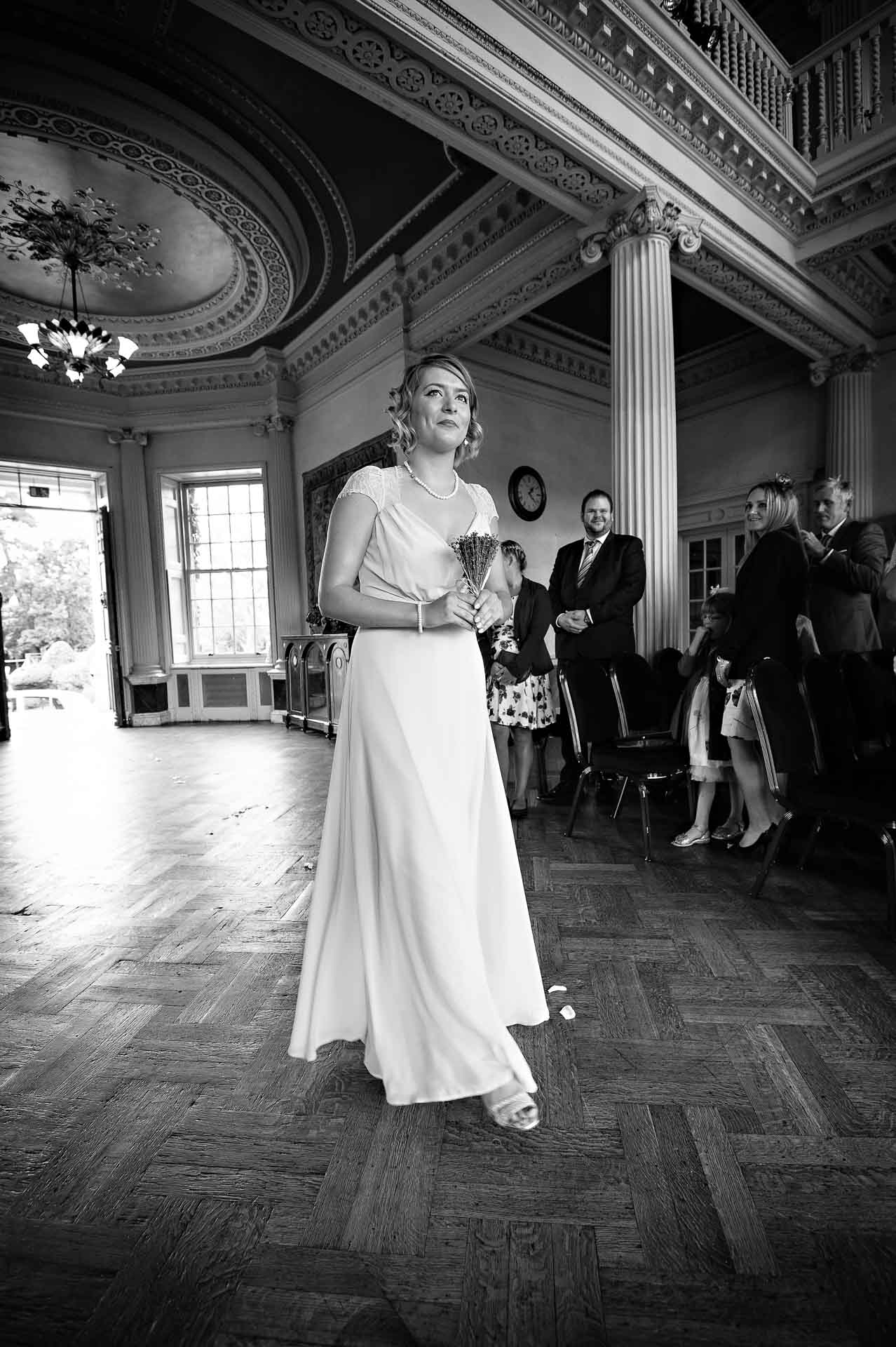 Bridesmaid walking into wedding ceremony in black and white