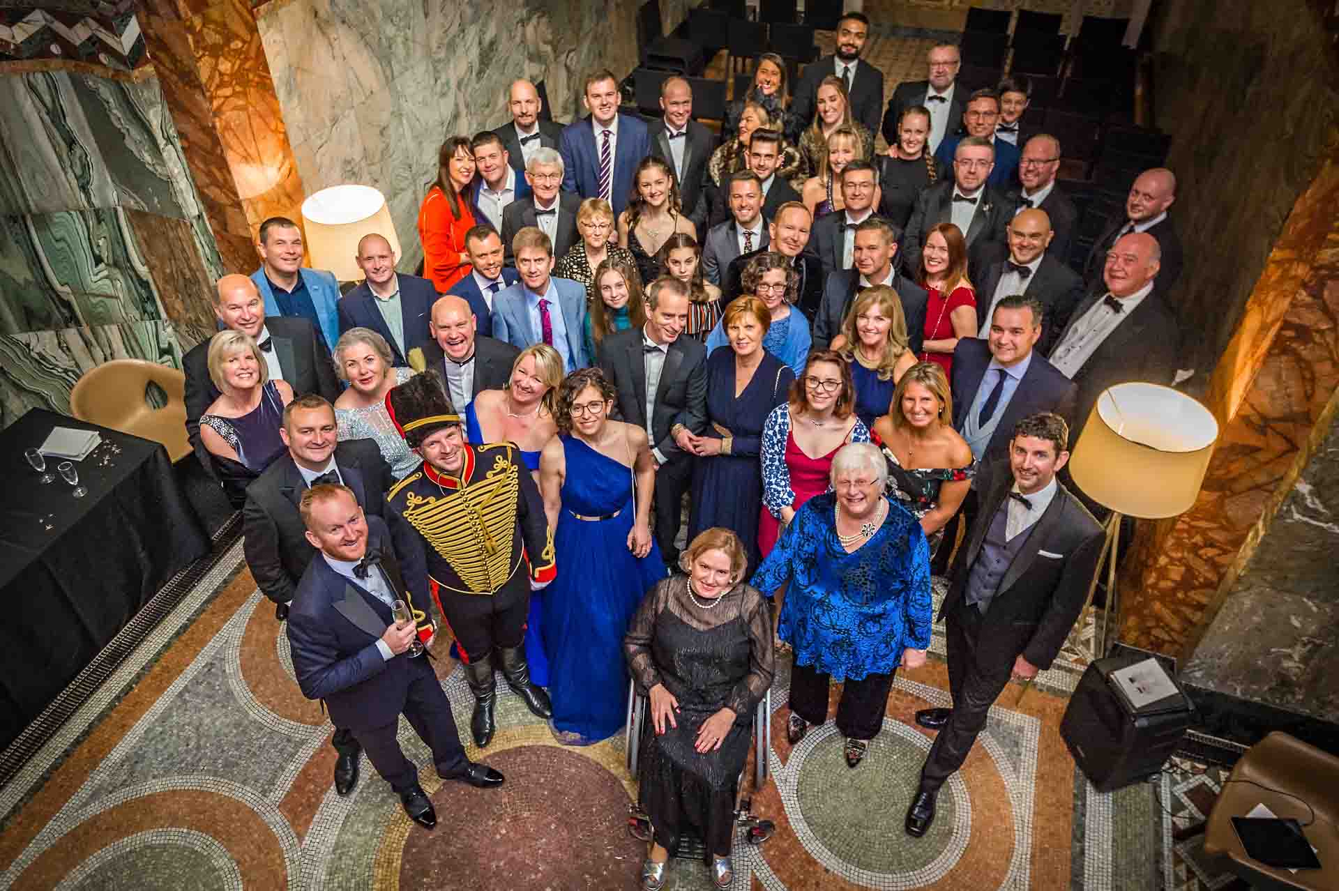 Group shot of all wedding guests taken from balcony at Fitzrovia Chapel in London