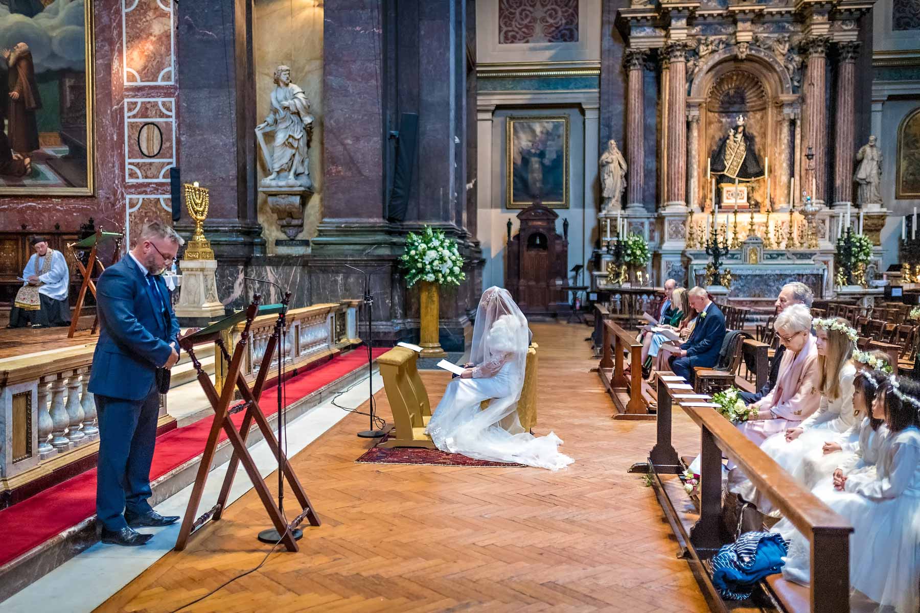 A wedding guests reads at a Brompton Oratory marriage ceremony