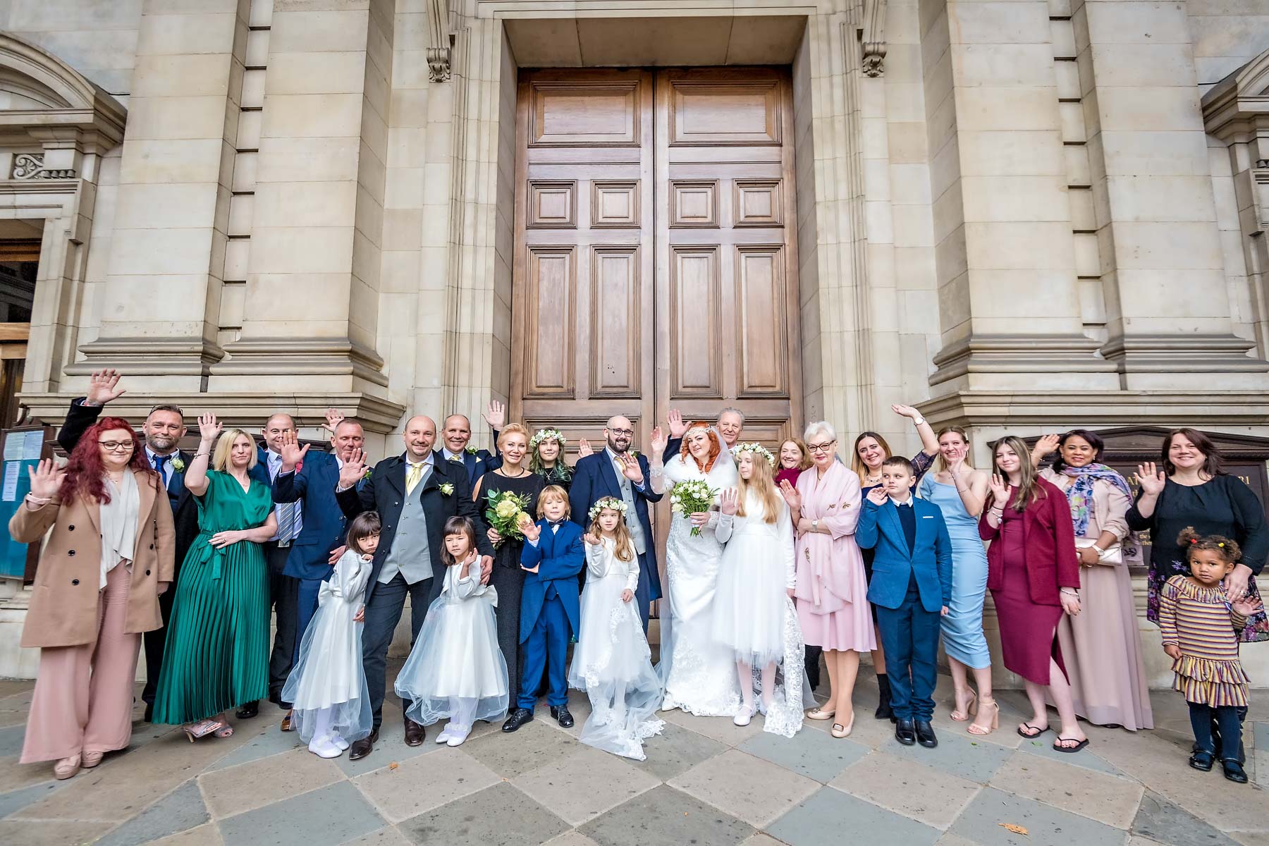 Group shot of all wedding guests outside Brompton Oratory in Knightsbridge, London