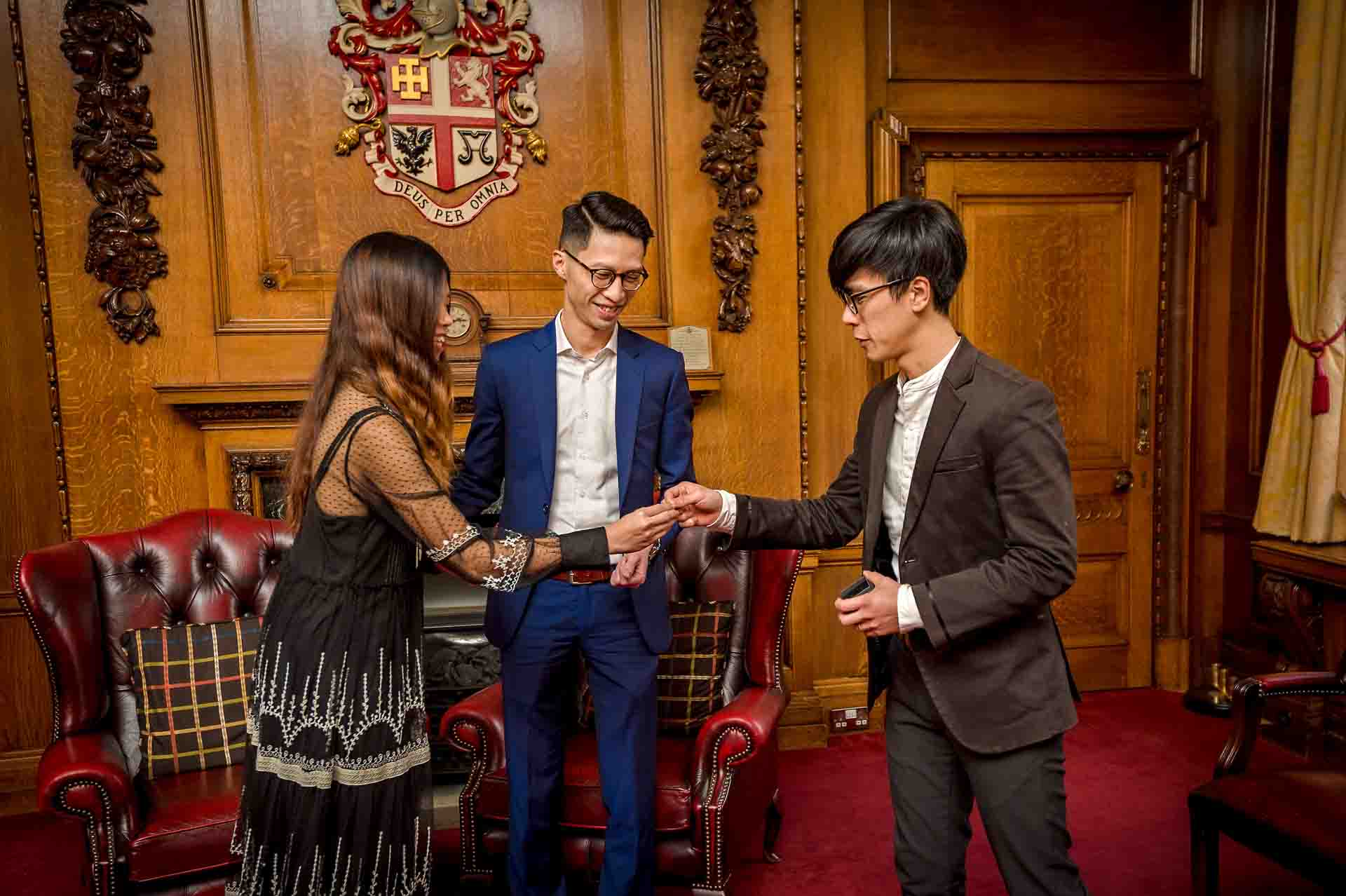 The smiling ring bearer hands the bride her ring at a wedding in Islington