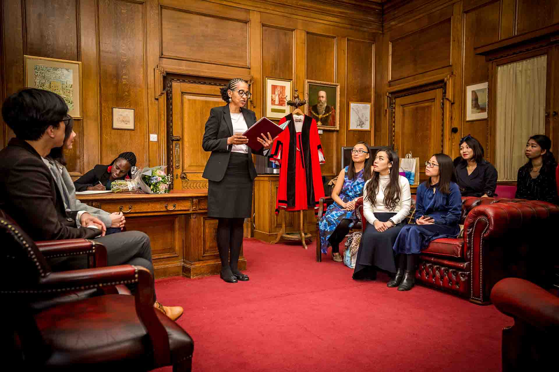 The registrar reads to guests prior to wedding starting at London City Register Office