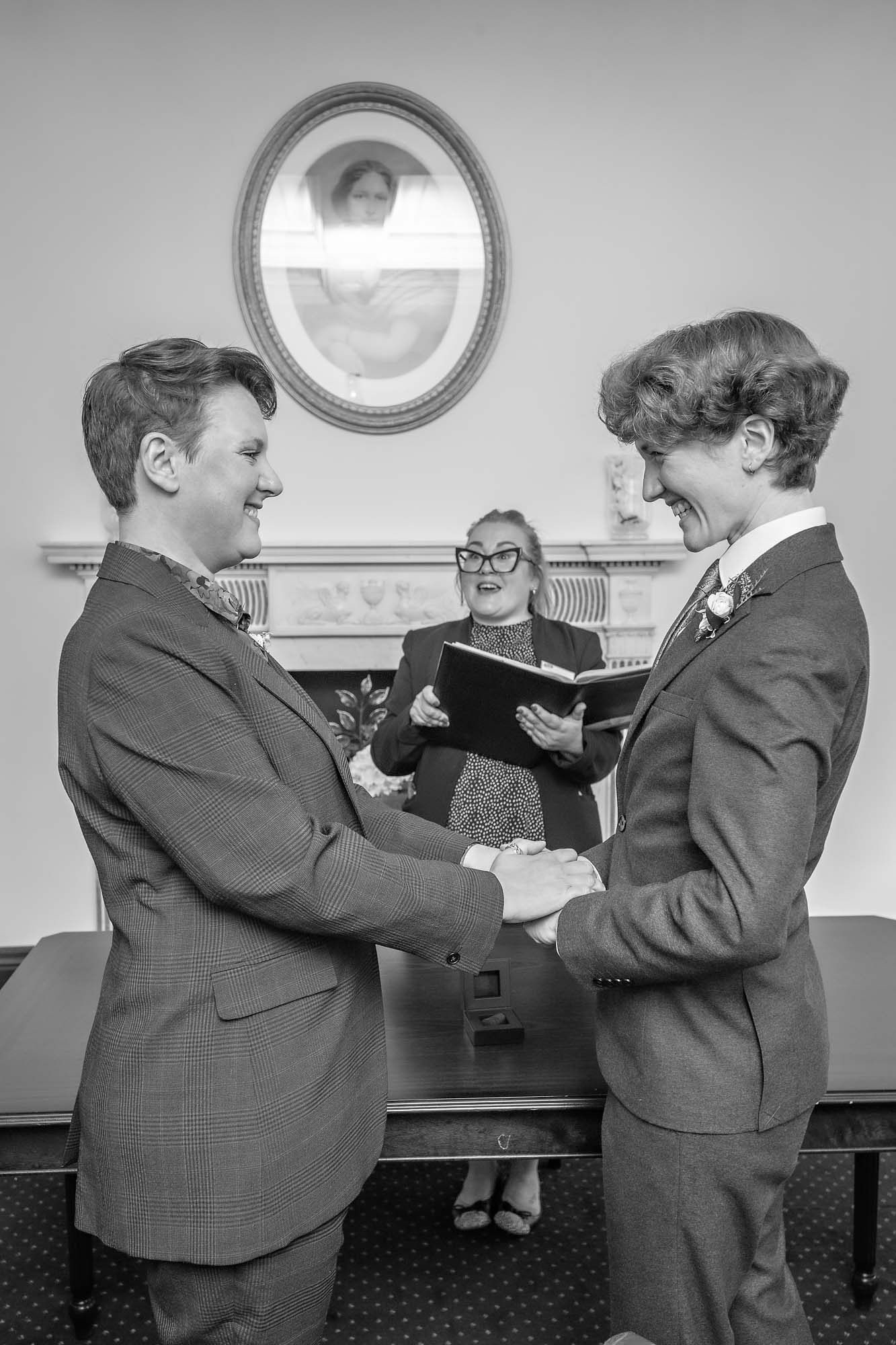 Same-sex brides excited and holding hands in Bromley wedding ceremony