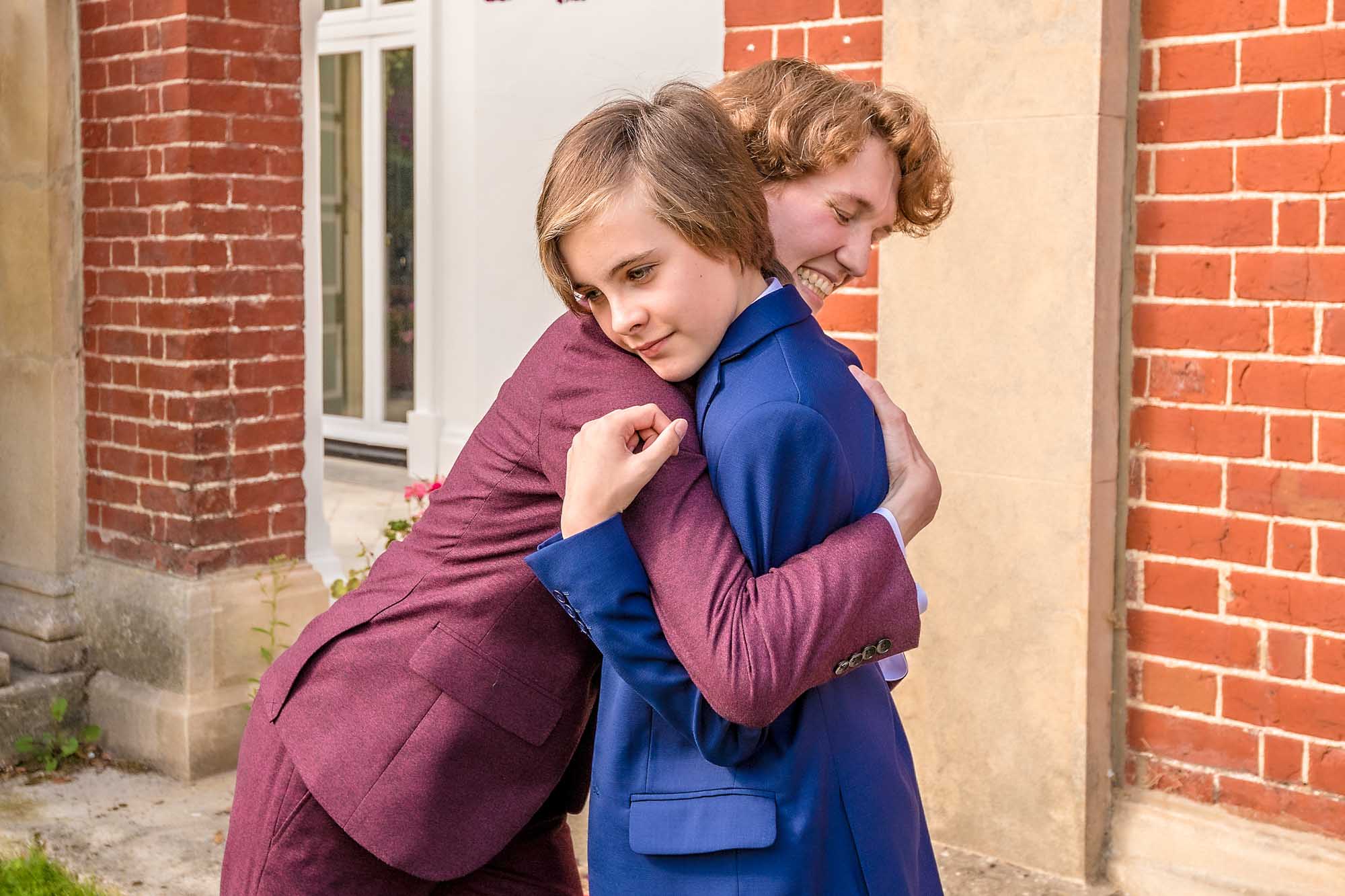 Suited bride hugs guest at wedding in Bromley Civic Centre