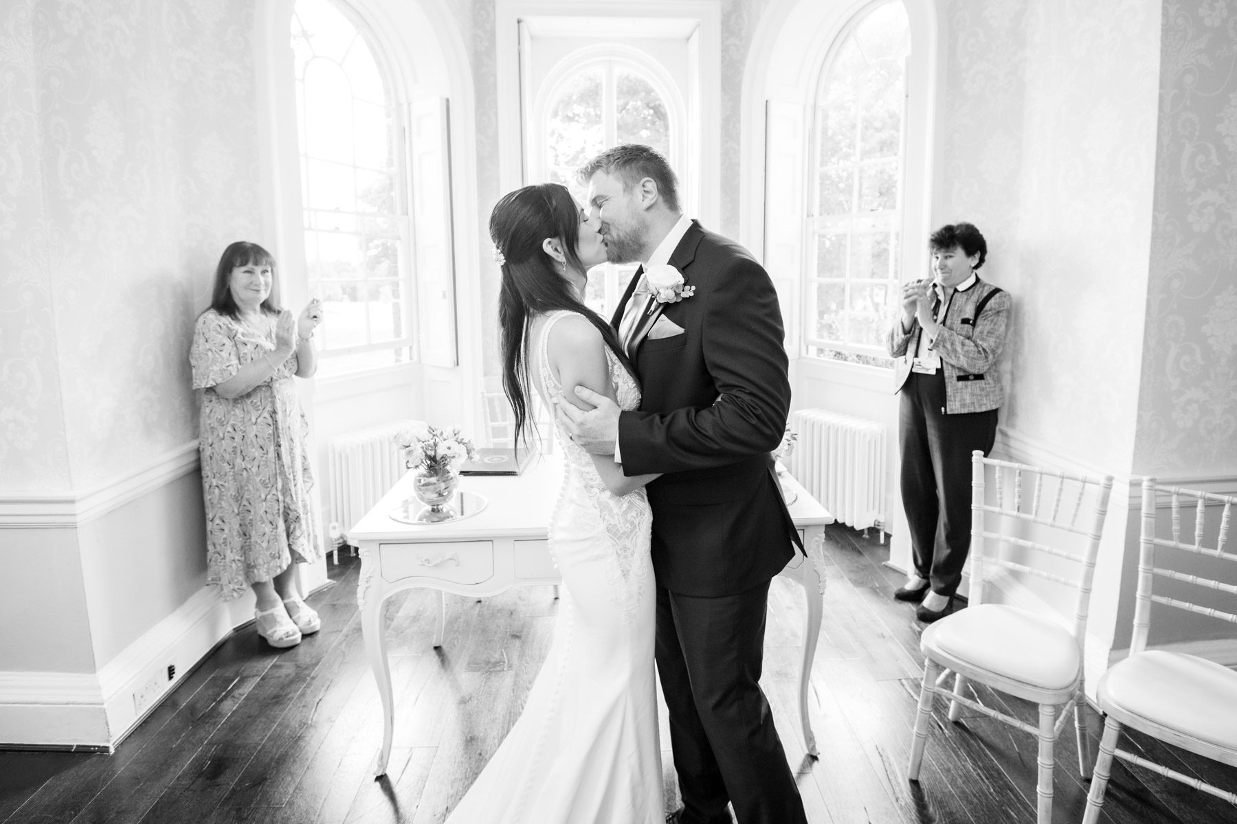 Black and white photo of couple kissing at their wedding in Morden Park House