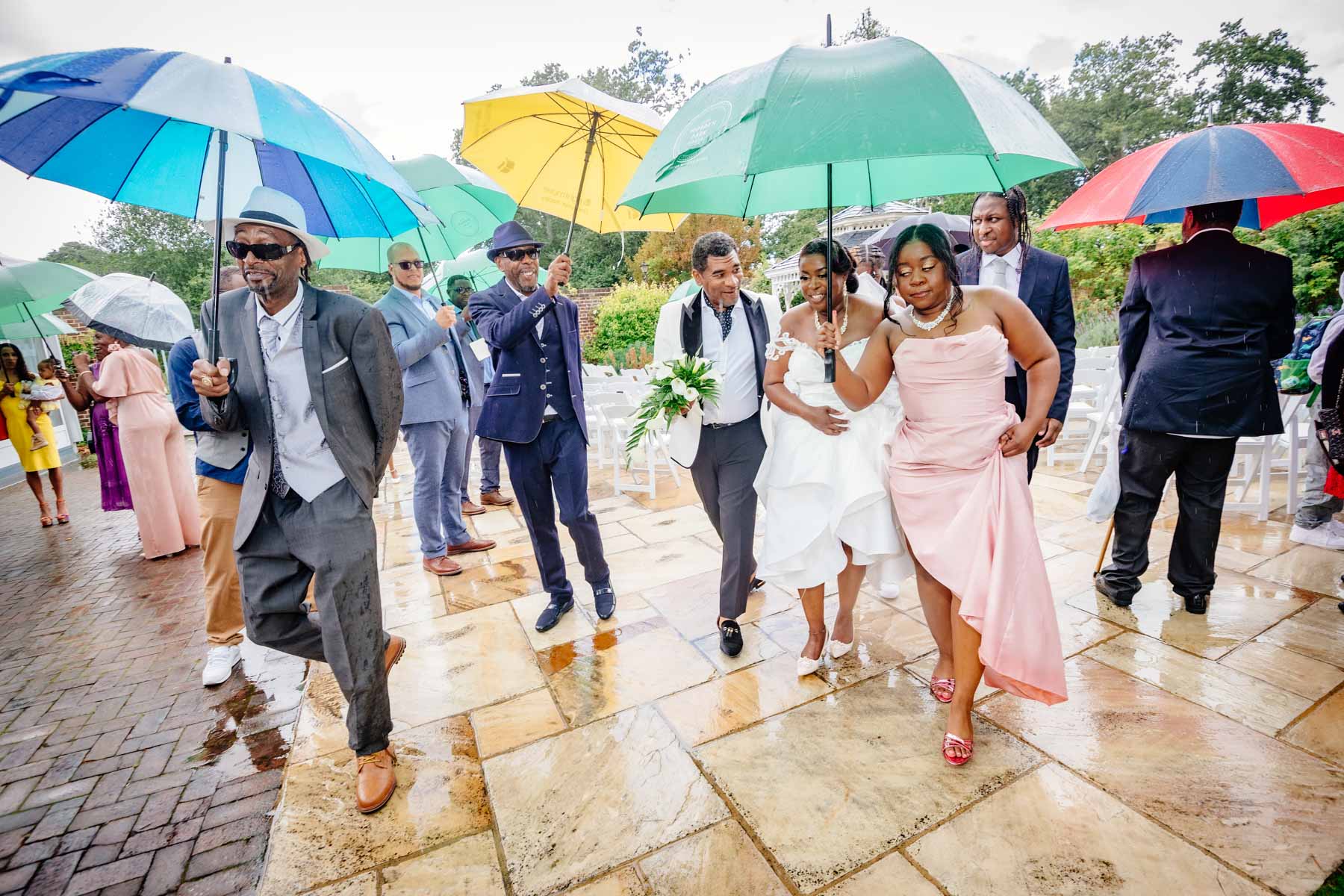The couple and their guests run for cover in the rain at Merton Register Office