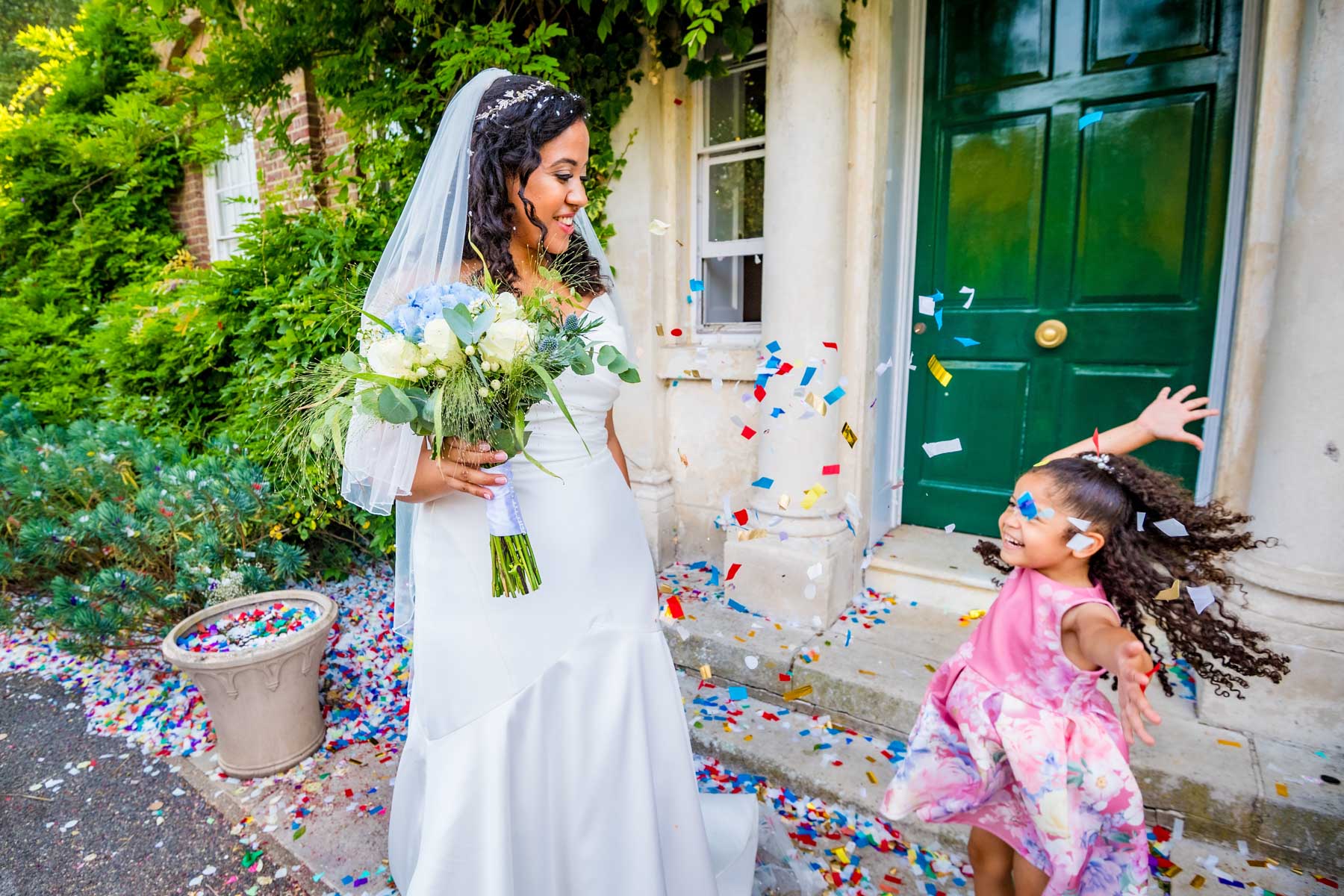 Girl toddler throwing confetti over bride in vibrant looking photo
