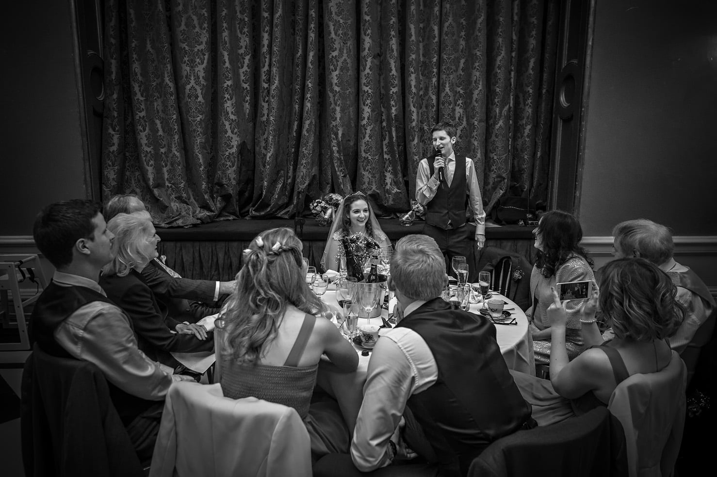 The groom gives his speech at round table in Hampton Court House