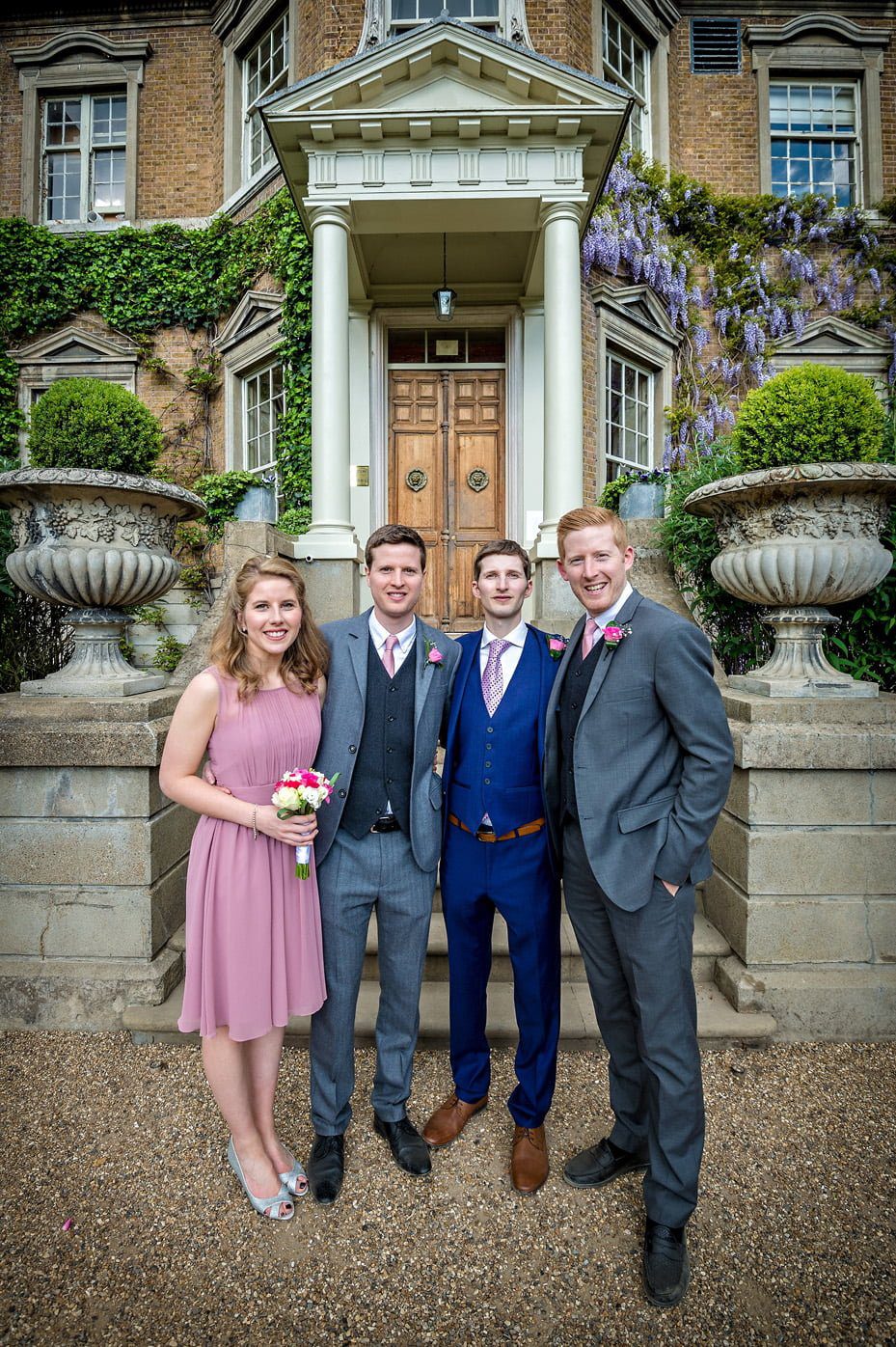 Groom with family members outside the front doors of Hampton Court House