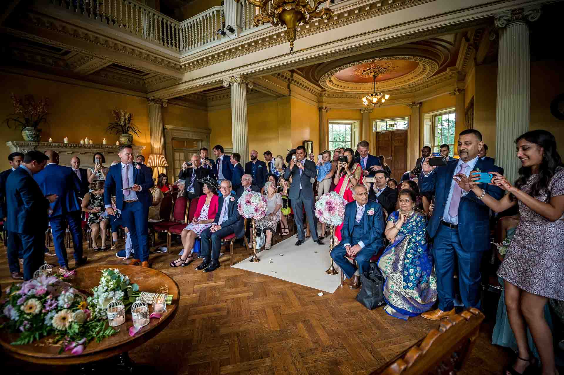 The guests take photos of the couple after their ceremony at Hampton Court House