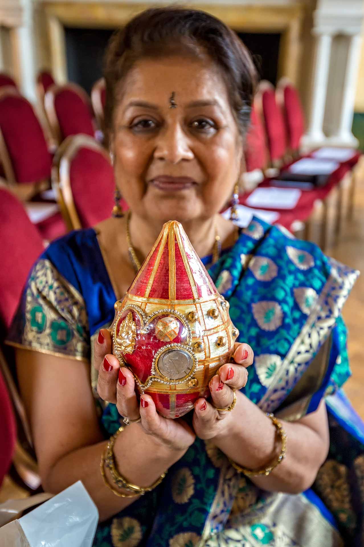 Bride's Indian mother holding the decorated coconut at Indian wedding