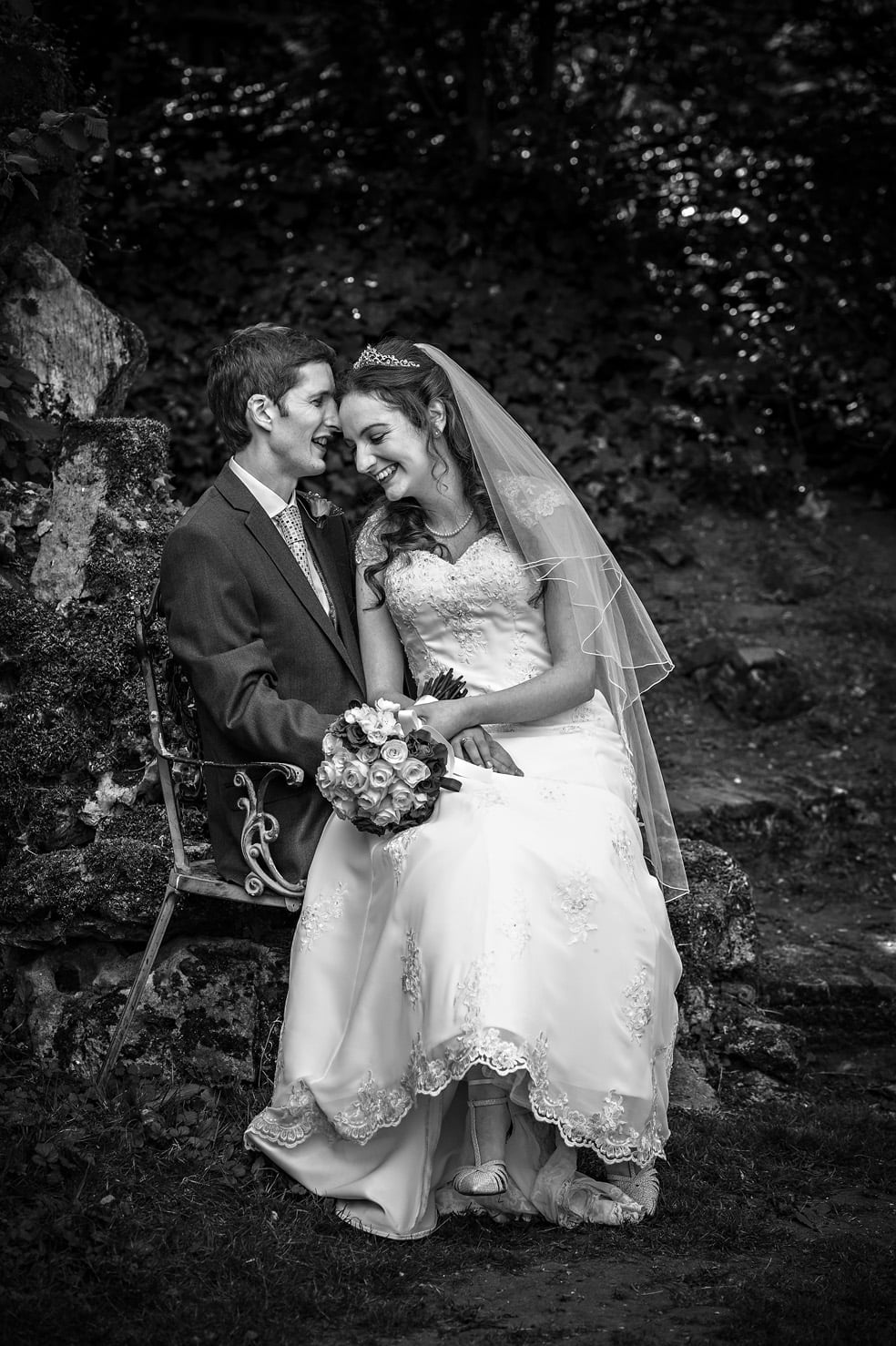 Black and white portrait of the newly-weds seated in garden of Hampton Court House