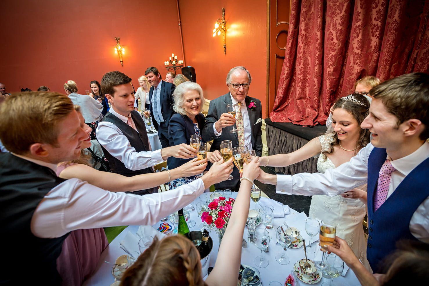 Top table all clink glasses at Hampton Court House wedding