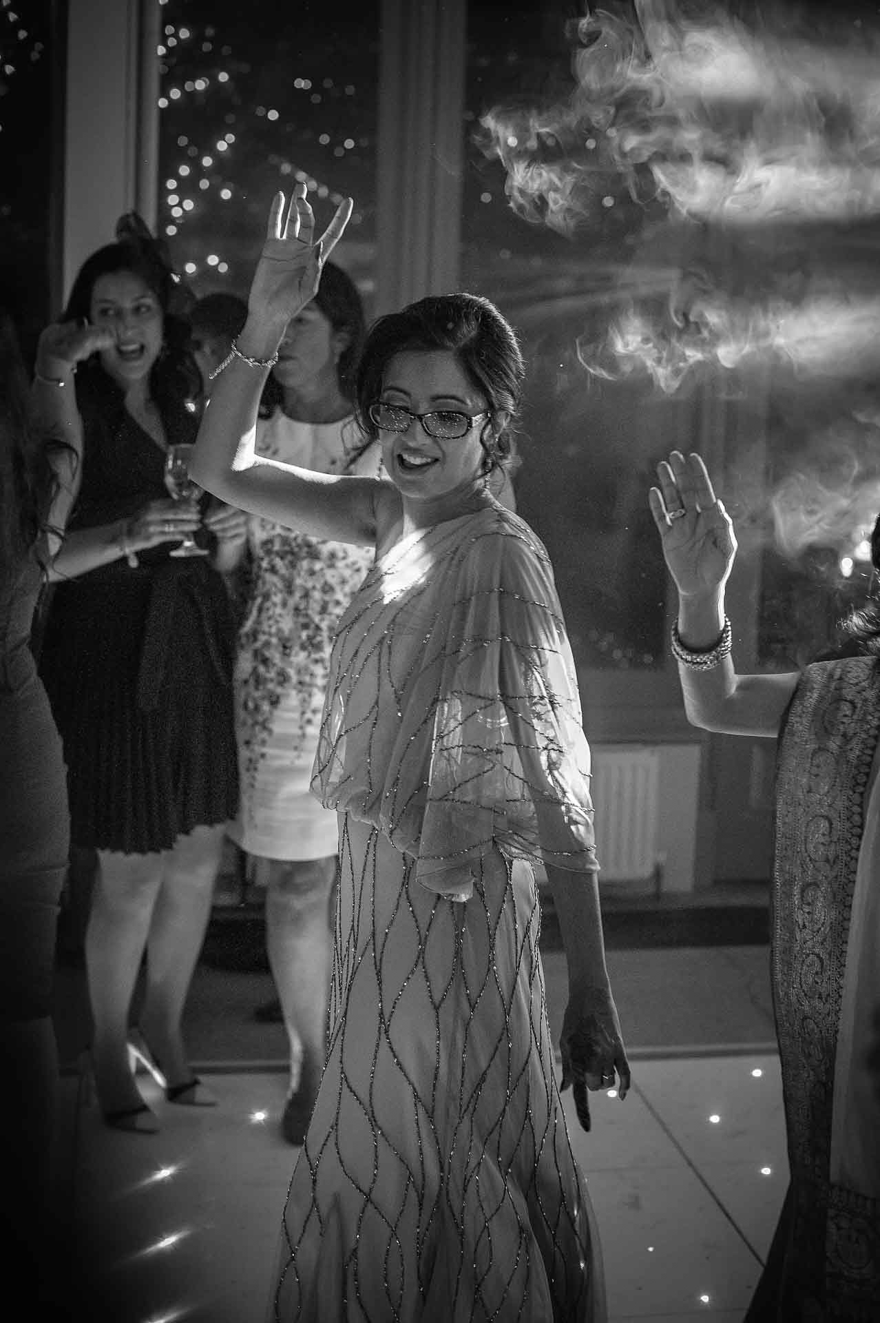 Female wedding guest dances with smoke above her