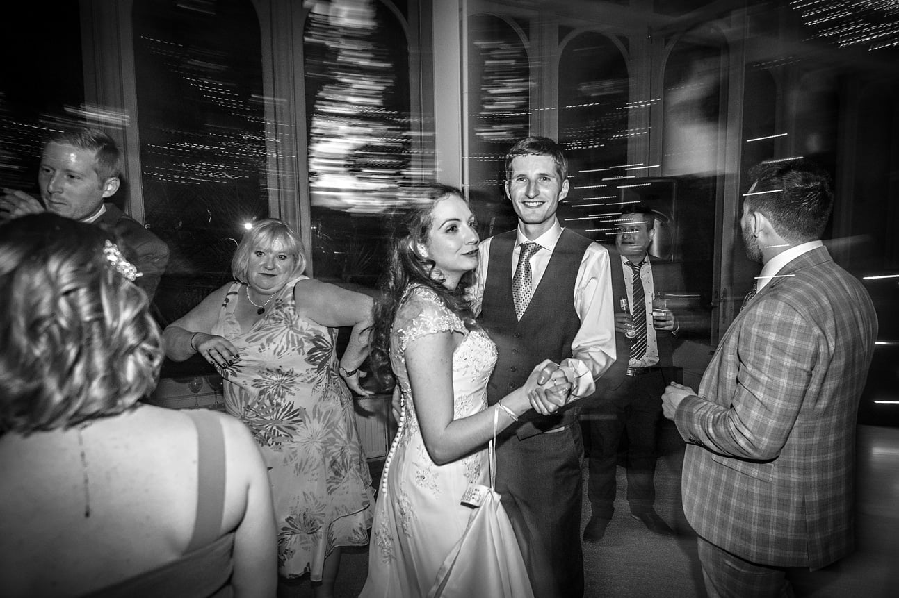 Bride and groom dancing with guests at Hampton Court House