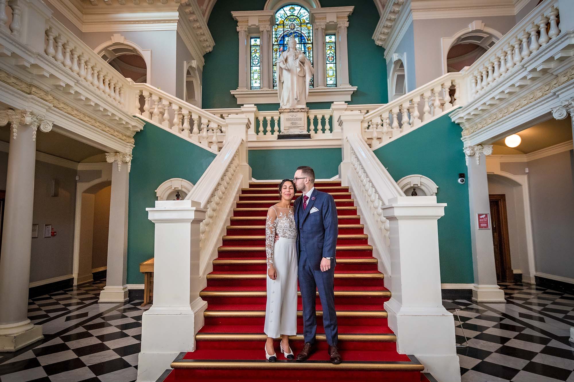 Groom kisses bride on stairs of the Victoria Hall, Greenwich Register Office