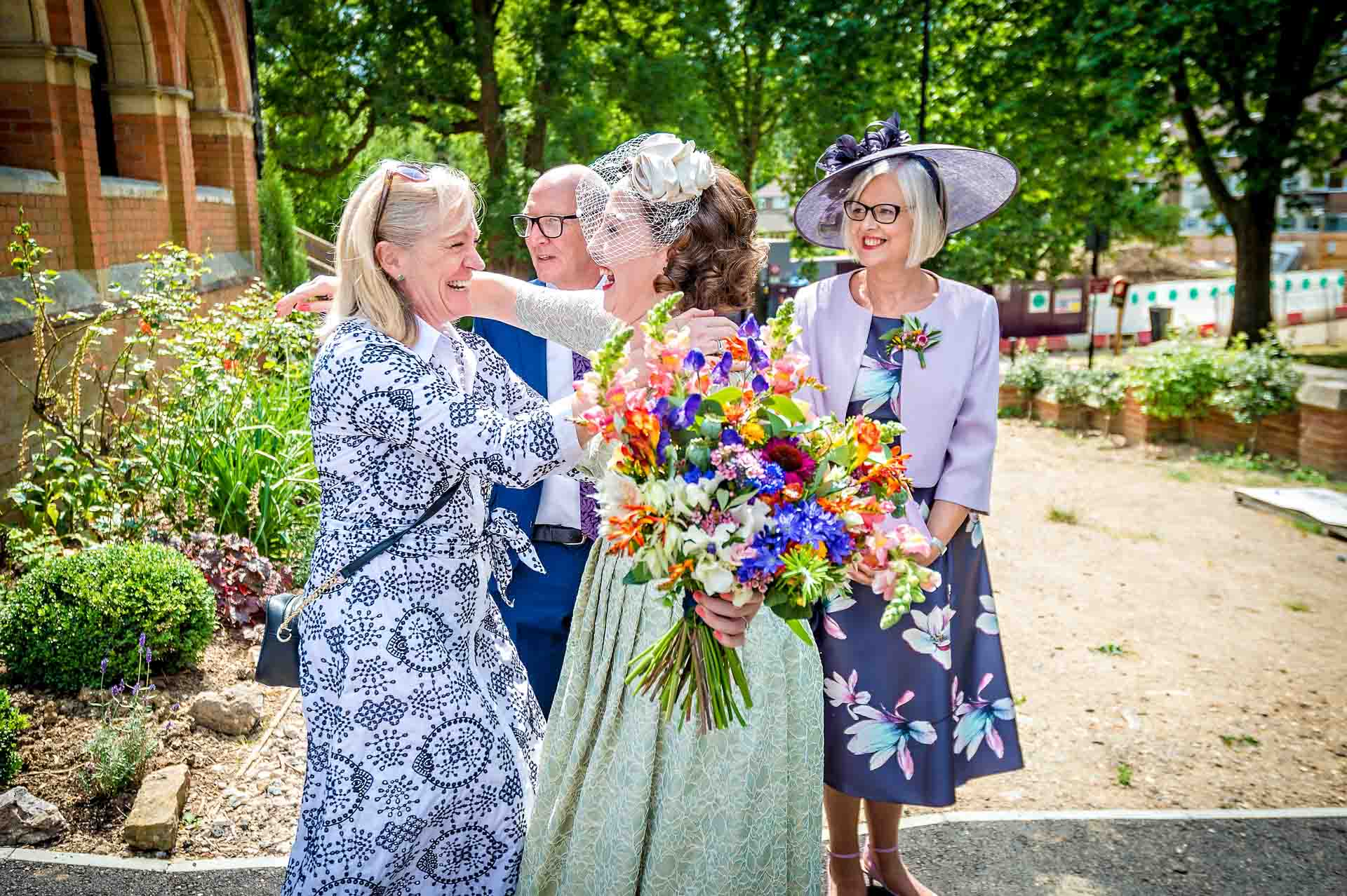 Bride excitedly greeting a friend outside church in Crystal Palace