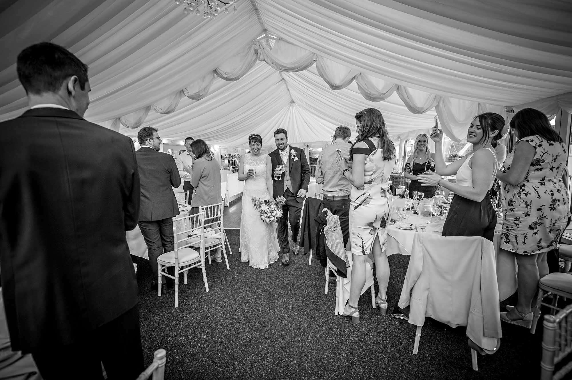 The happy couple enter the Marquee at the New House Country Hotel for their reception with guests applauding them