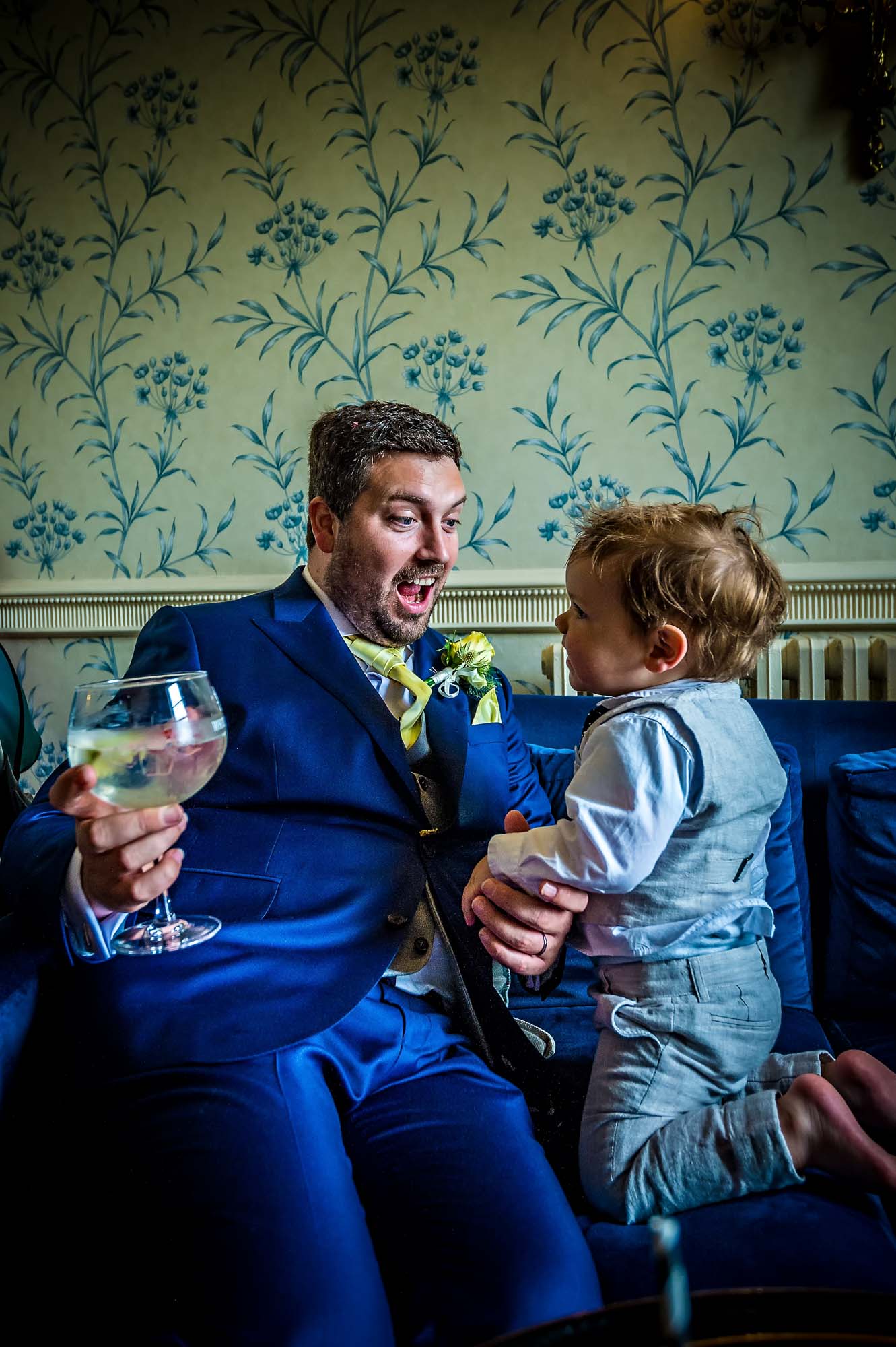 The groom interacting with toddler at wedding