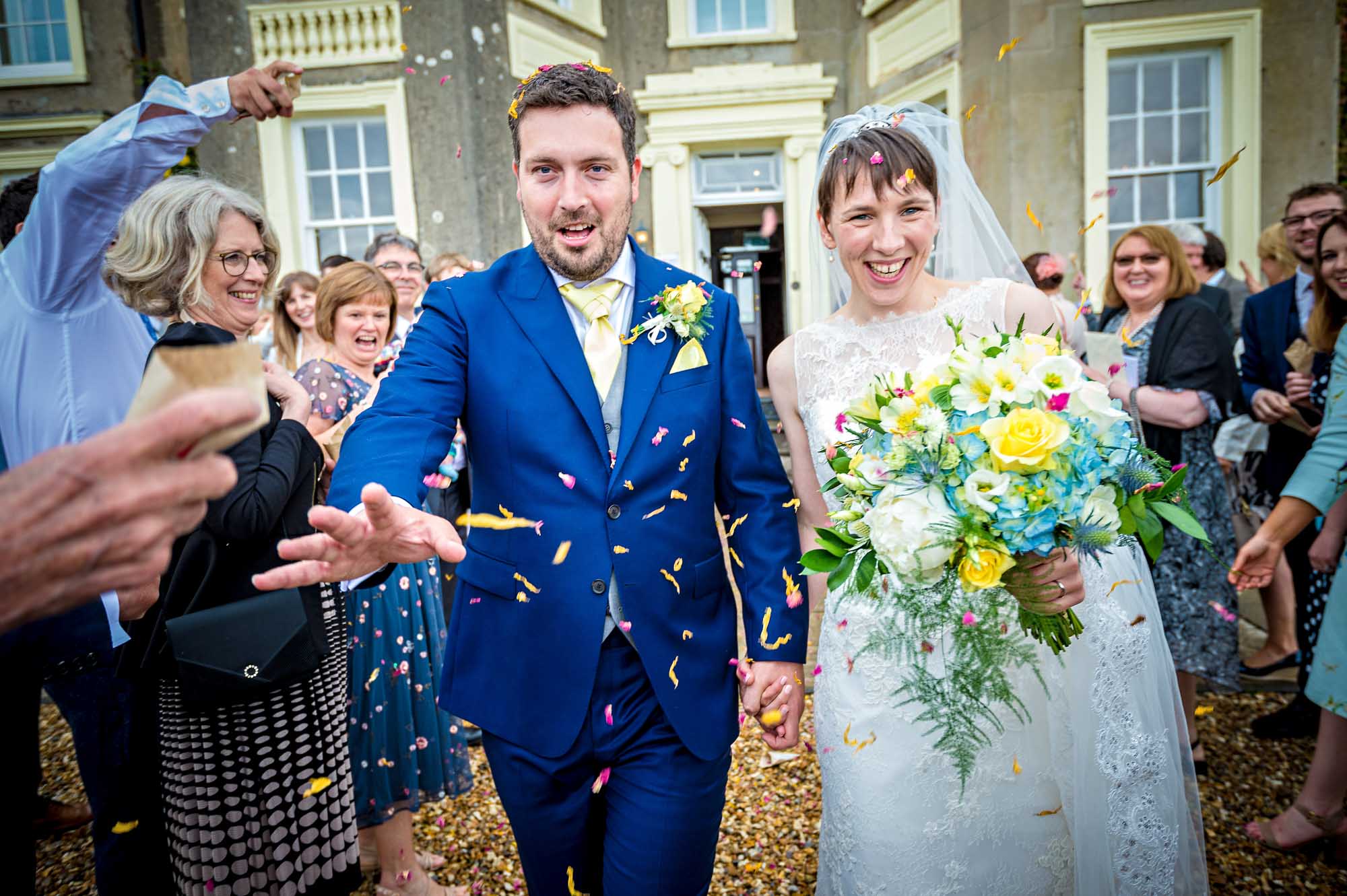 The groom holds out hand and looks concerned as the photographer nearly falls into the fountain at New House Country Hotel