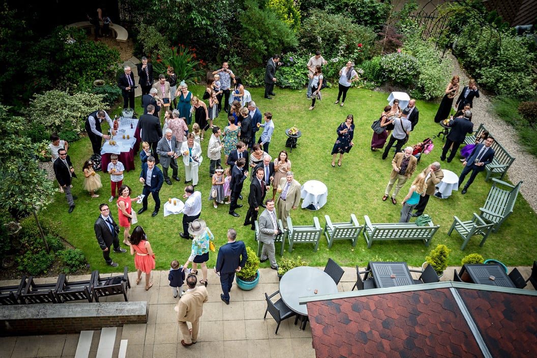 Guests at wedding drinks reception on lawn taken from above