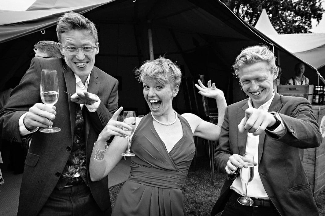 Wedding guests larking around for the camera in black and white