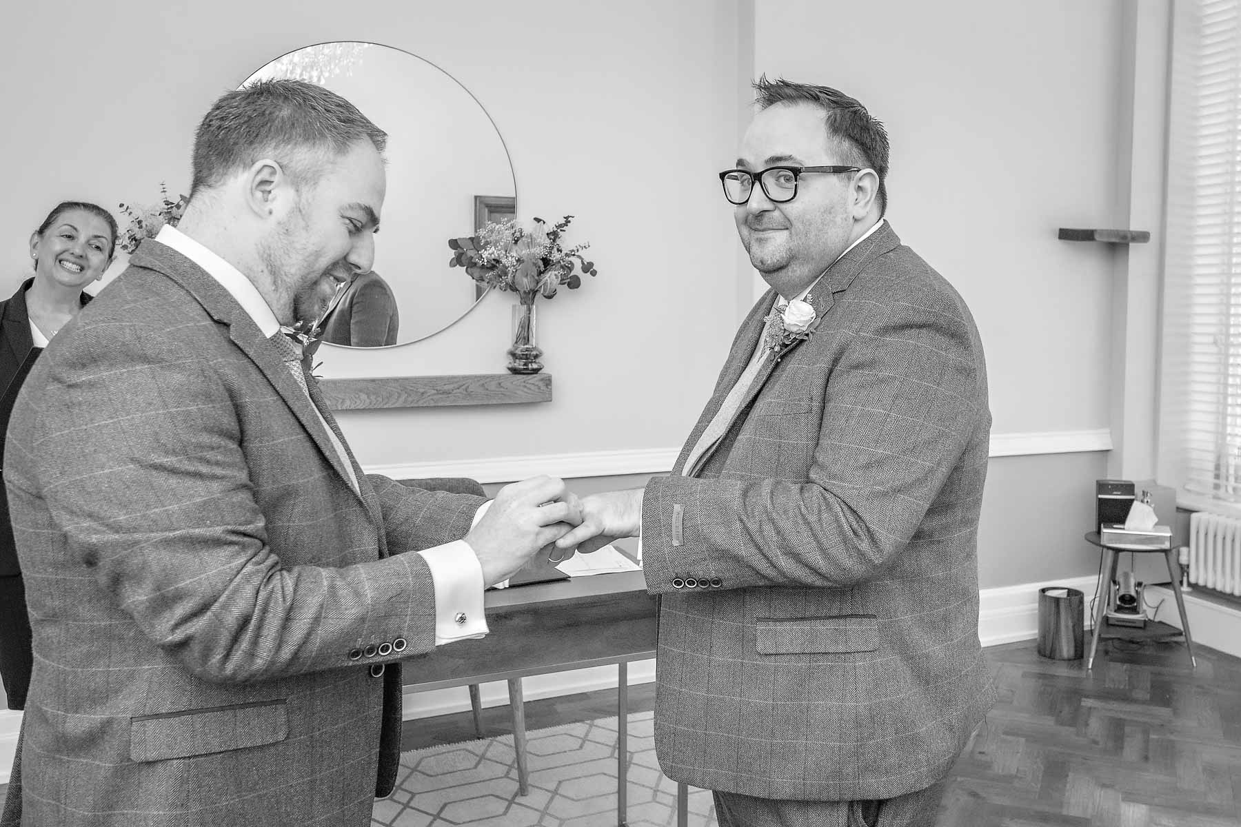 At a gay wedding in Islington Town Hall, the grooms' exchange rings - black and white photograph