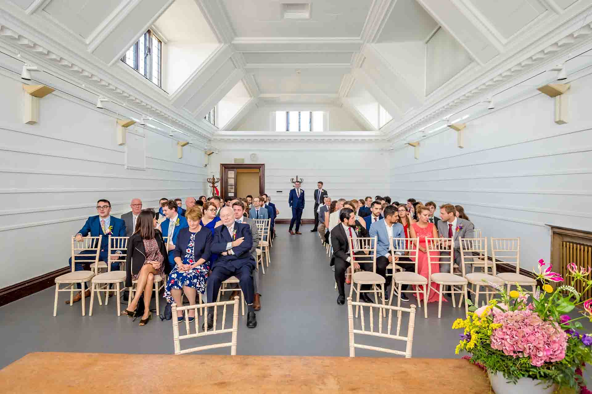 Wide overview of wedding guests seated before the ceremony