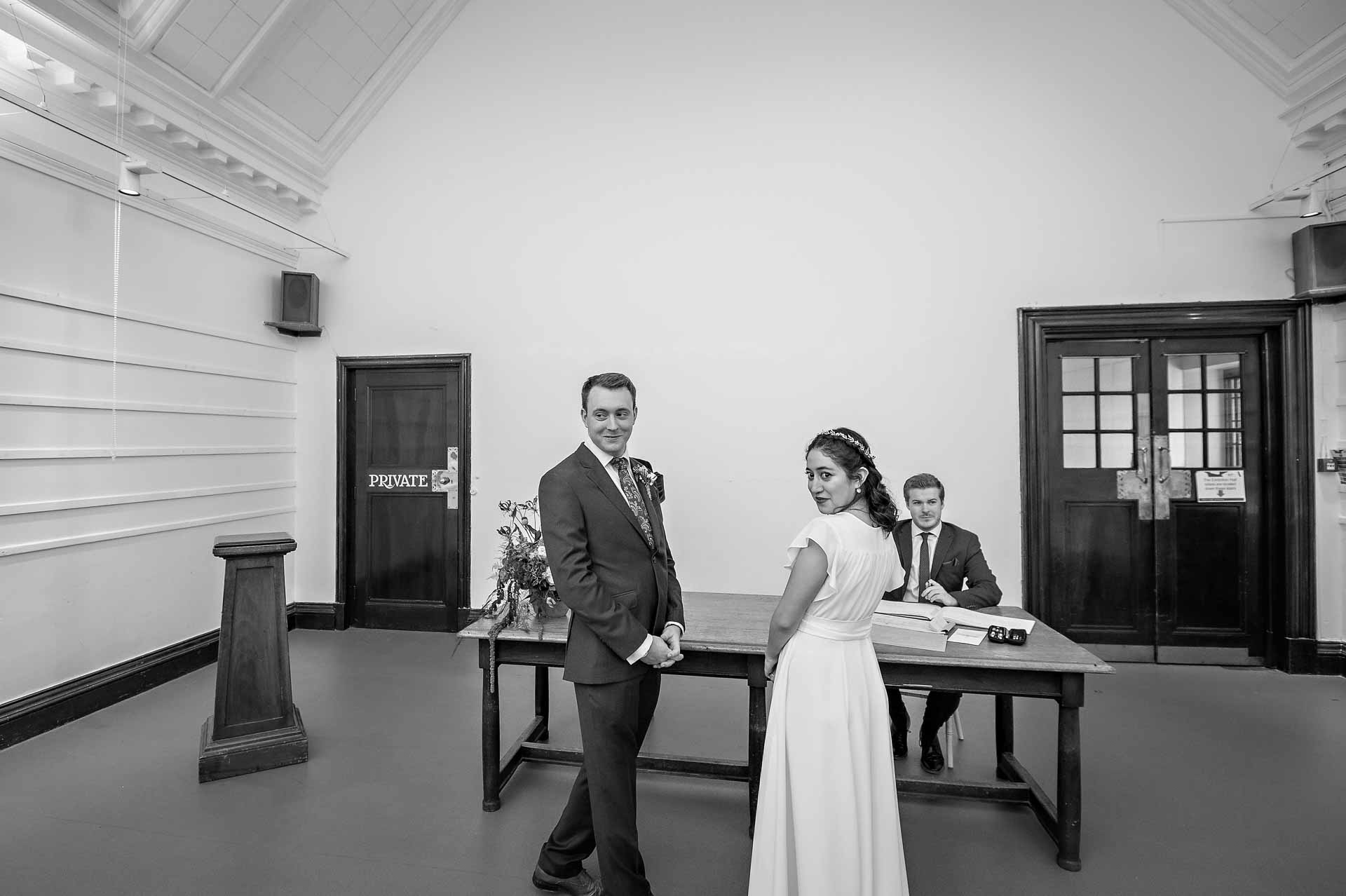 Happy couple turning to look at guests during wedding ceremony