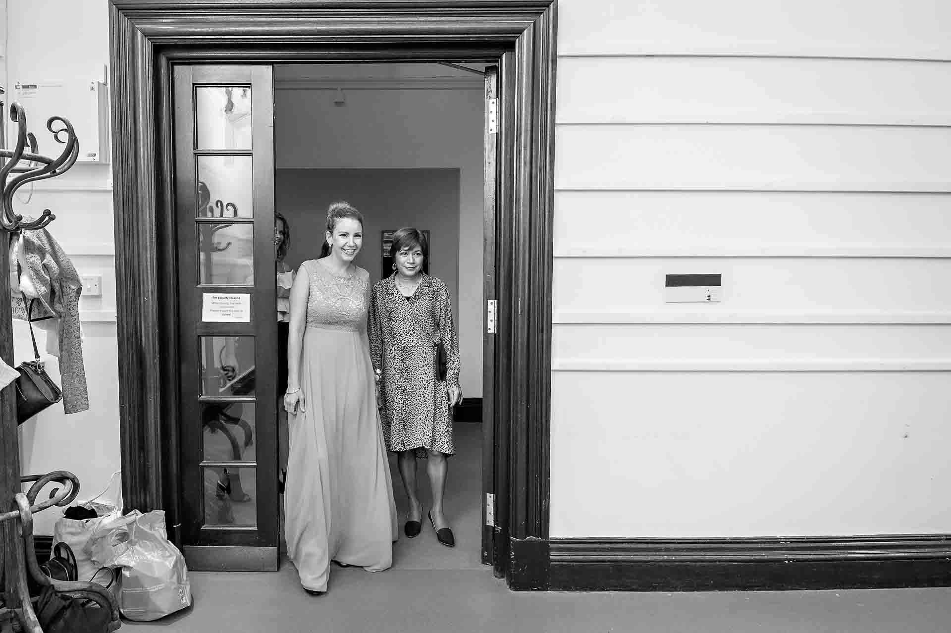 Bridesmaid and mother of bride entering exhibition room at Fulham Library