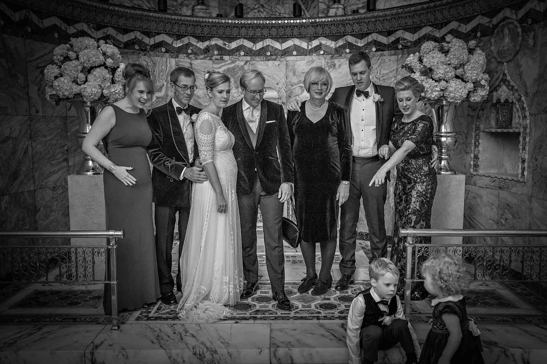 Group Wedding Photo Taken at the Fitzrovia Chapel with Two Children Unwilling to Take Part