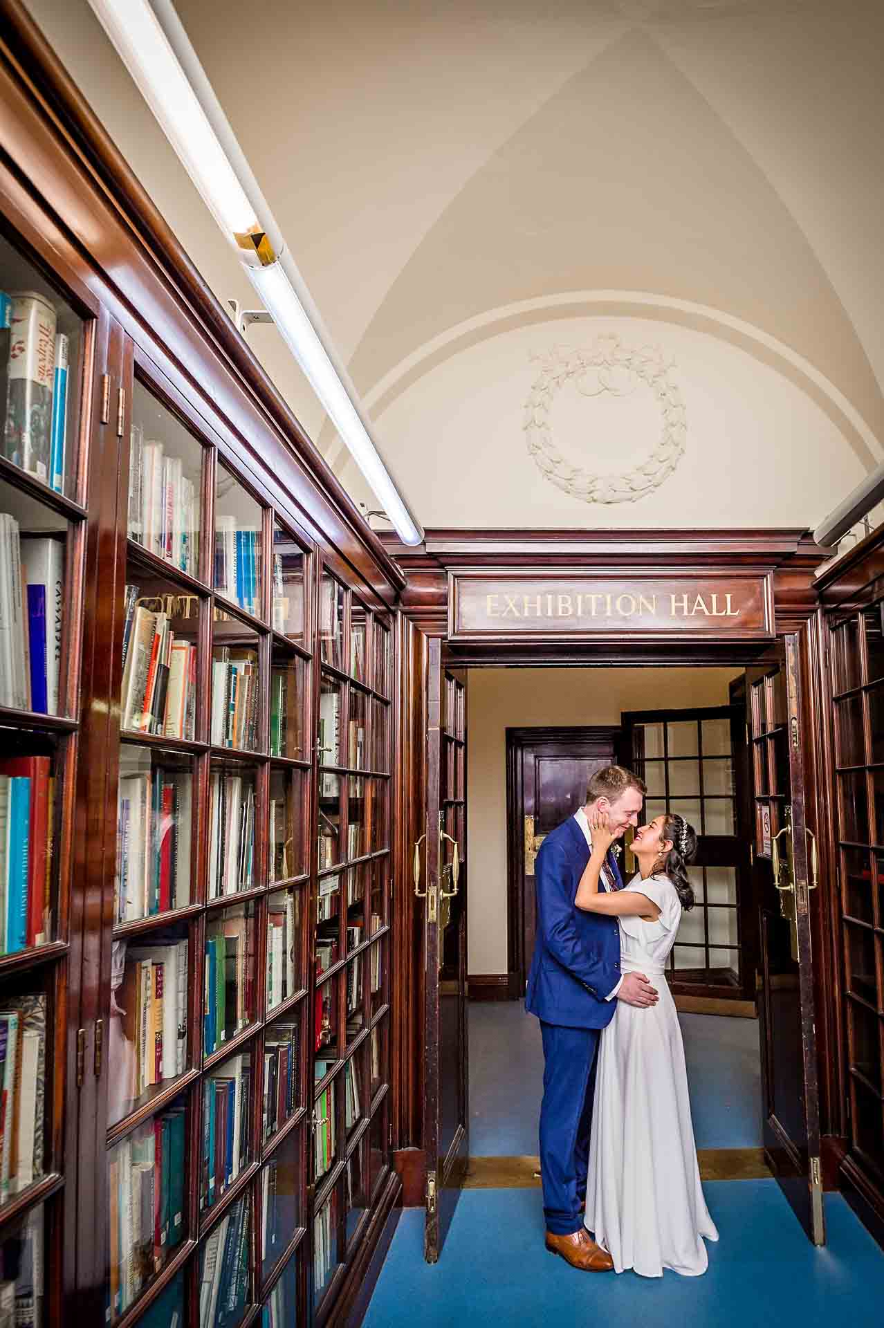 Bride and Groom pose in the Fine Art Collection Corridor at Fulham Library