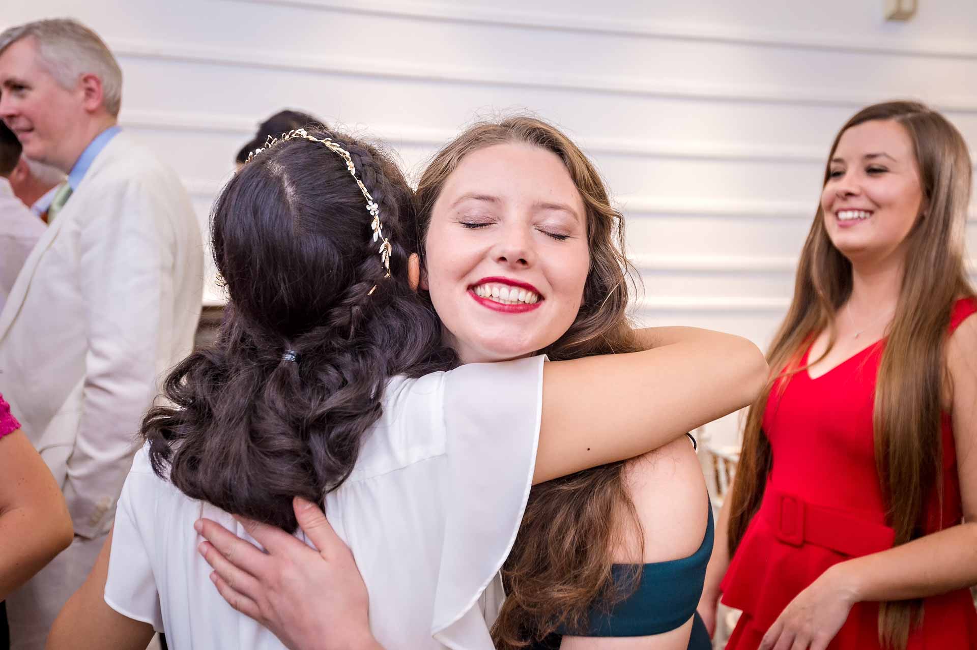 Bride and friend hug after wedding in London