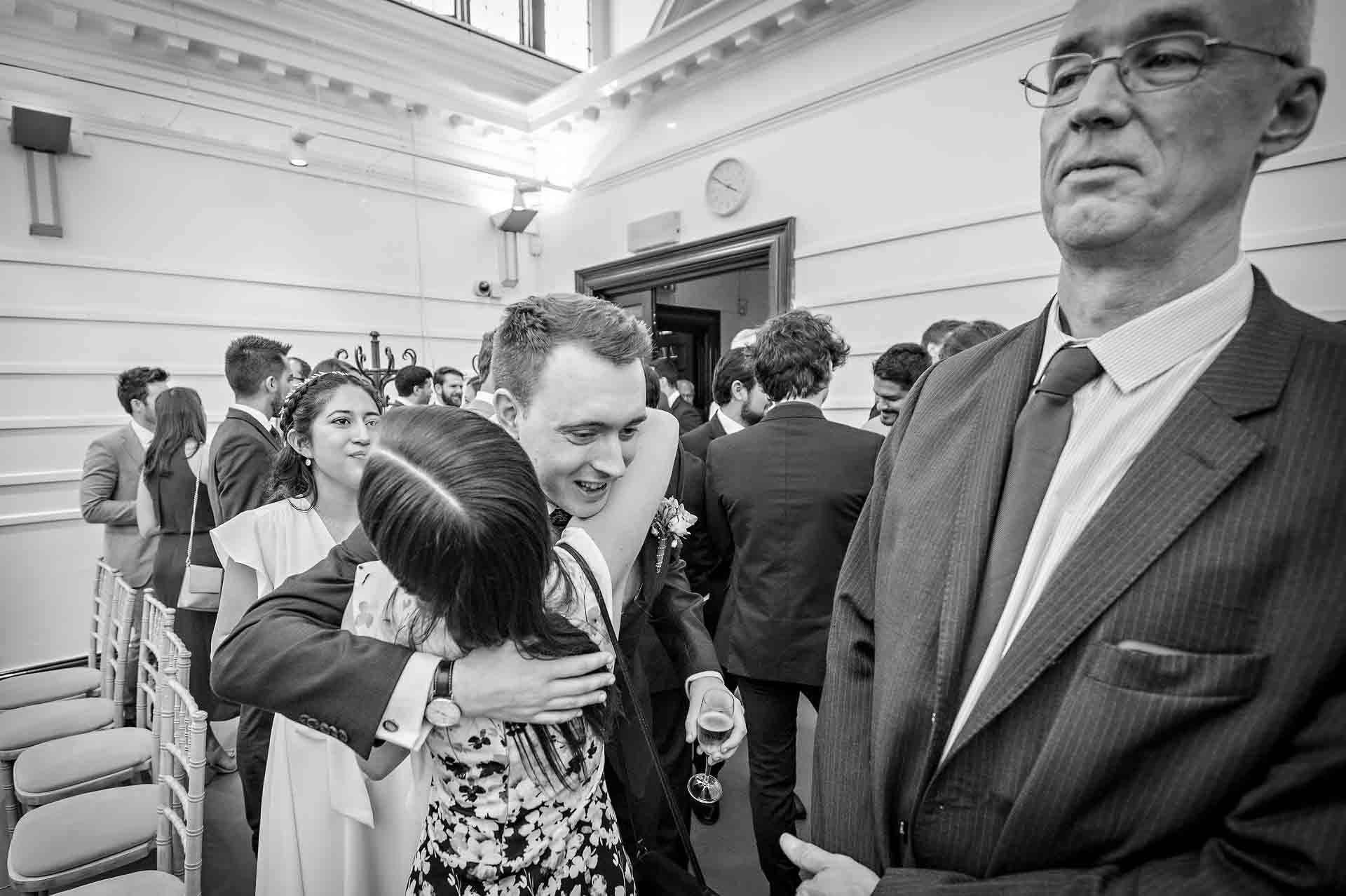 Groom hugs guest after marriage ceremony