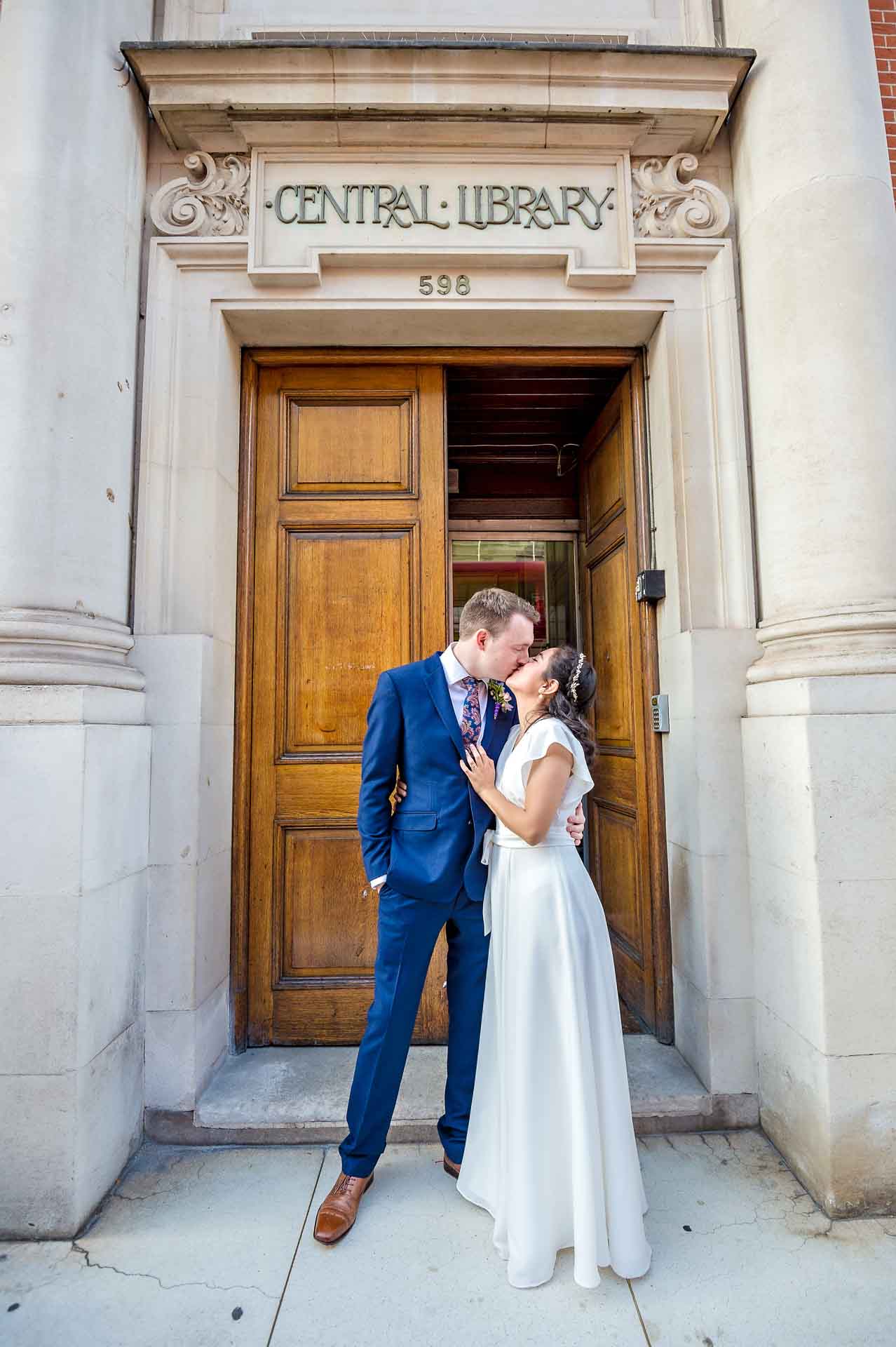 Portrait of Bride and Groom kissing outside Fulham Library