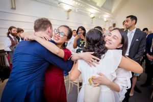 Guests hug the bride and groom at wedding in Fulham Library