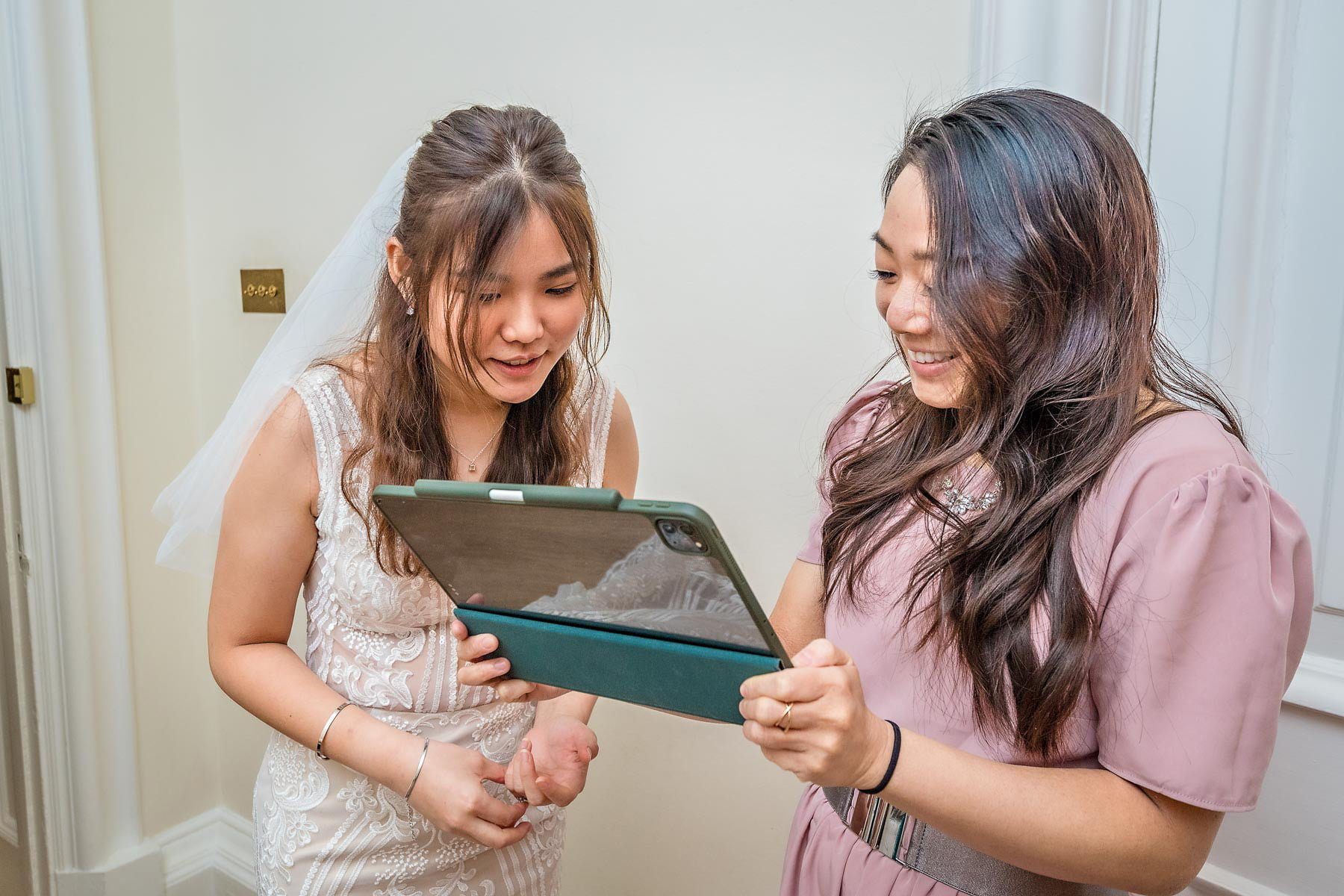 The bride and her sister set up an iPad to record the wedding ceremony at Greenwich Register Office