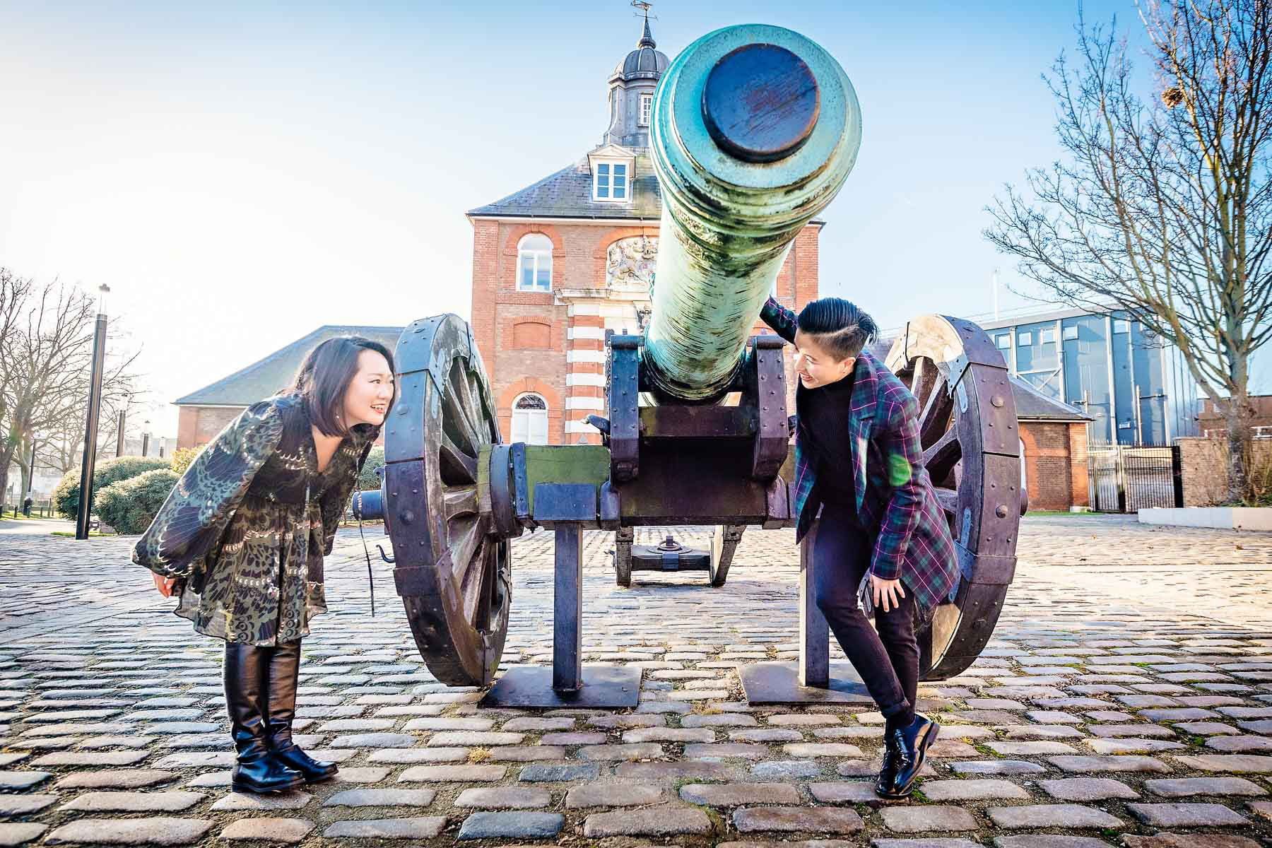 A female couple looking at each other under the barrel of a cannon in Woolwich, London