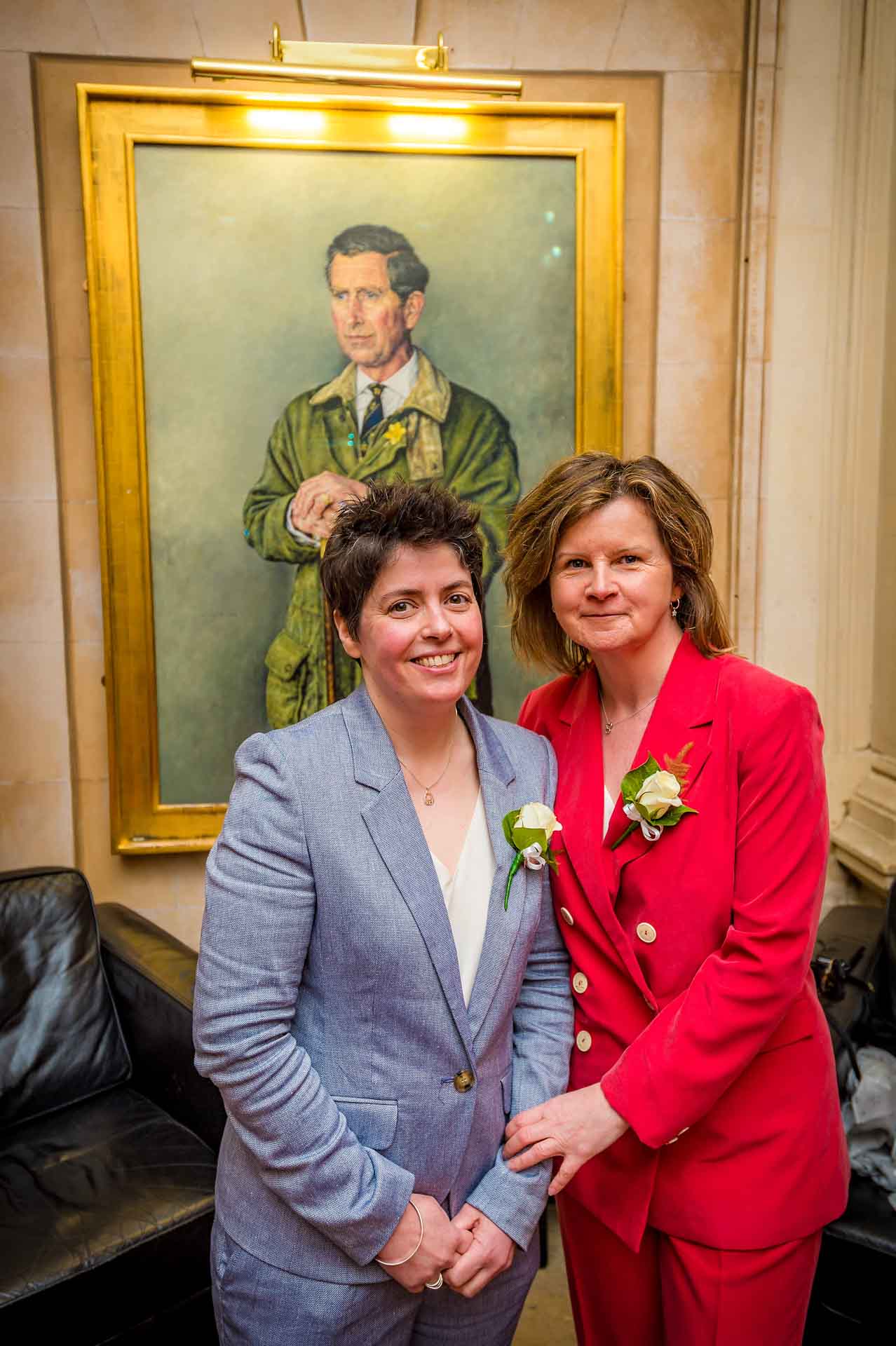 Female LGBT couple in front of portrait of the Prince of Wales