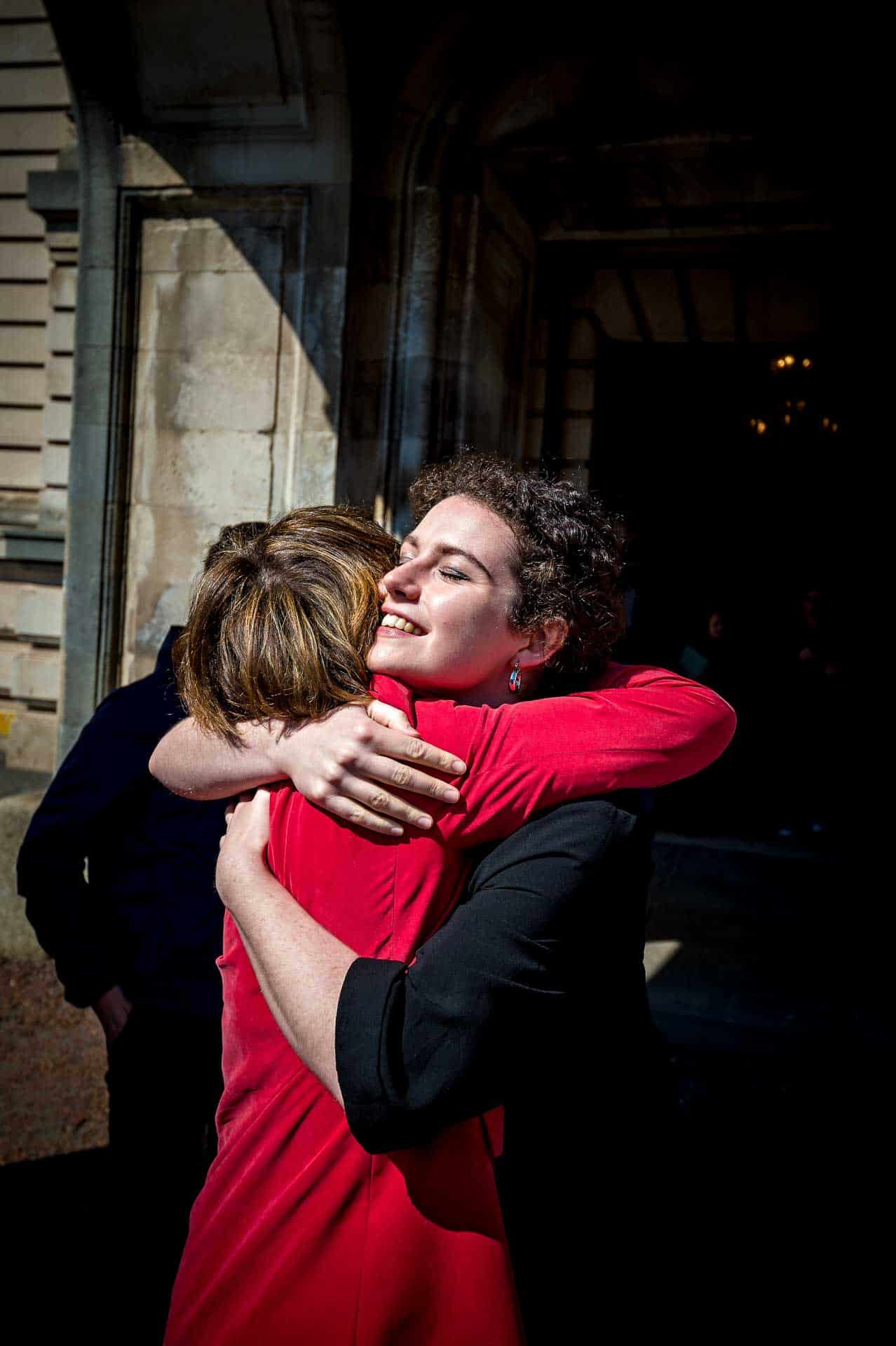 Bride hugging female relative outside Cardiff City Hall