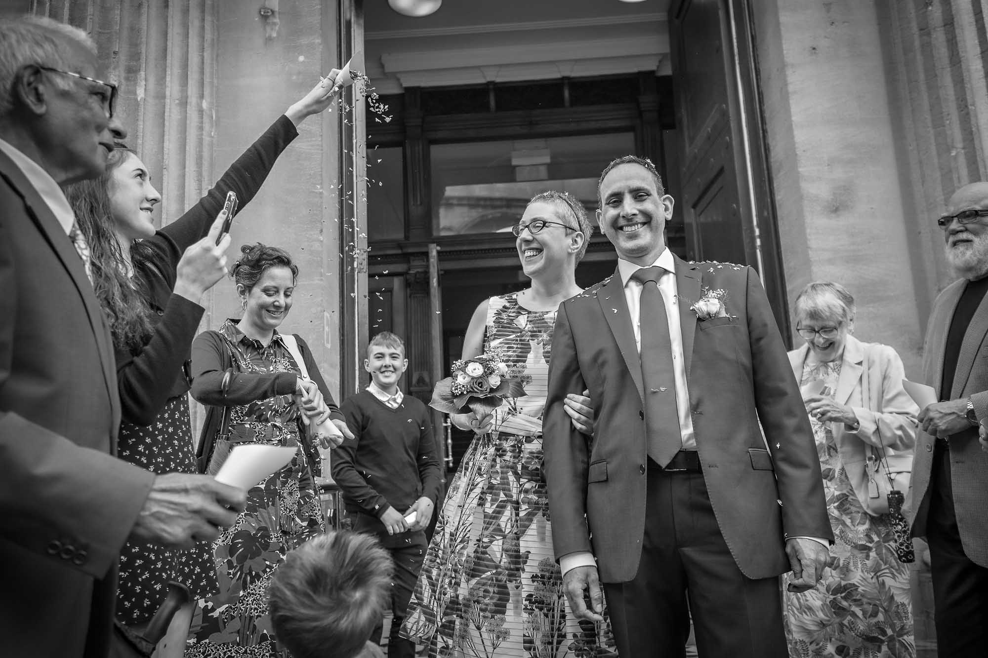 Wedding photo in black and white of confetti and couple laughing