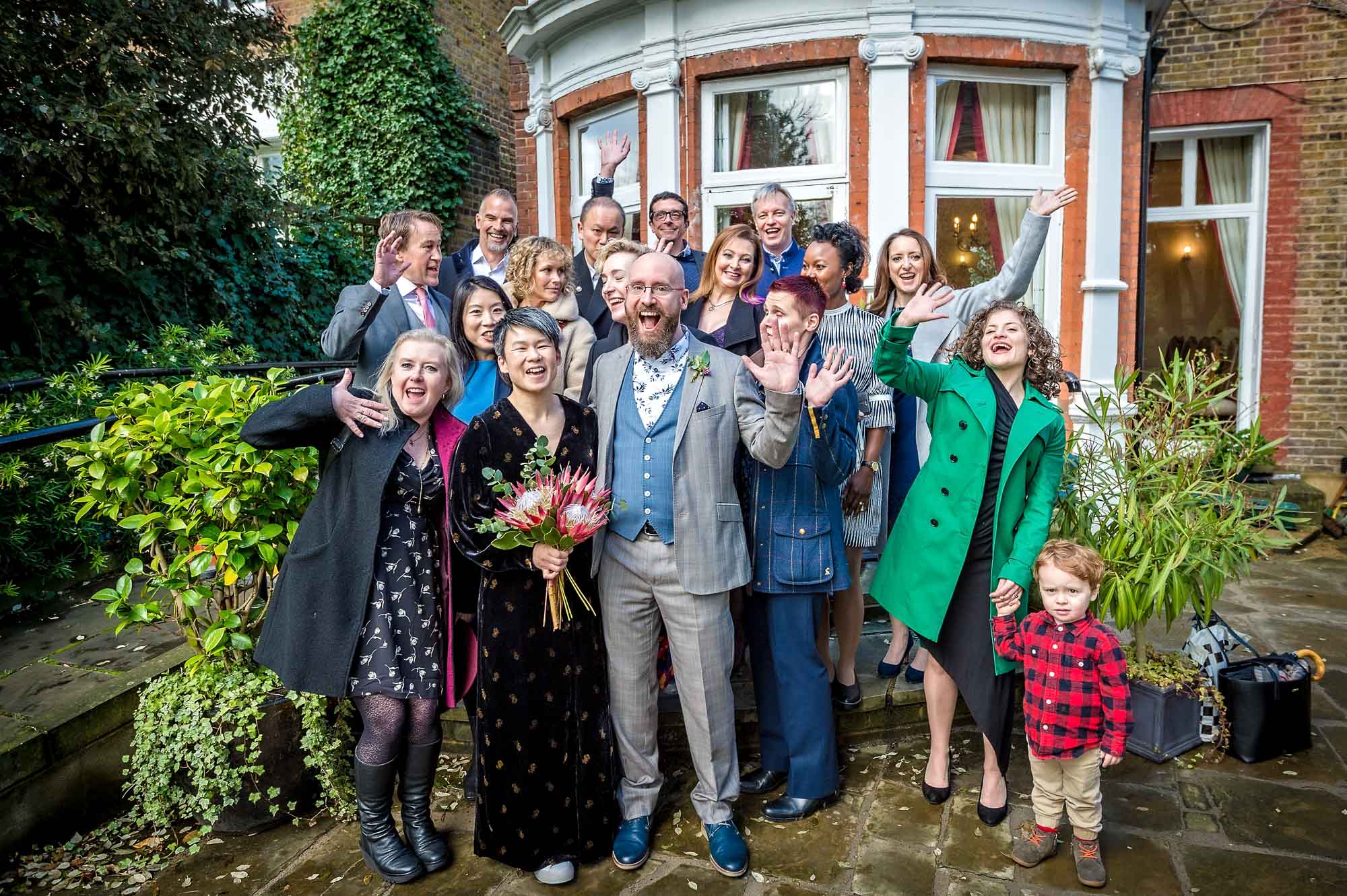 Group portrait outside Southwark Town Hall with guests waving