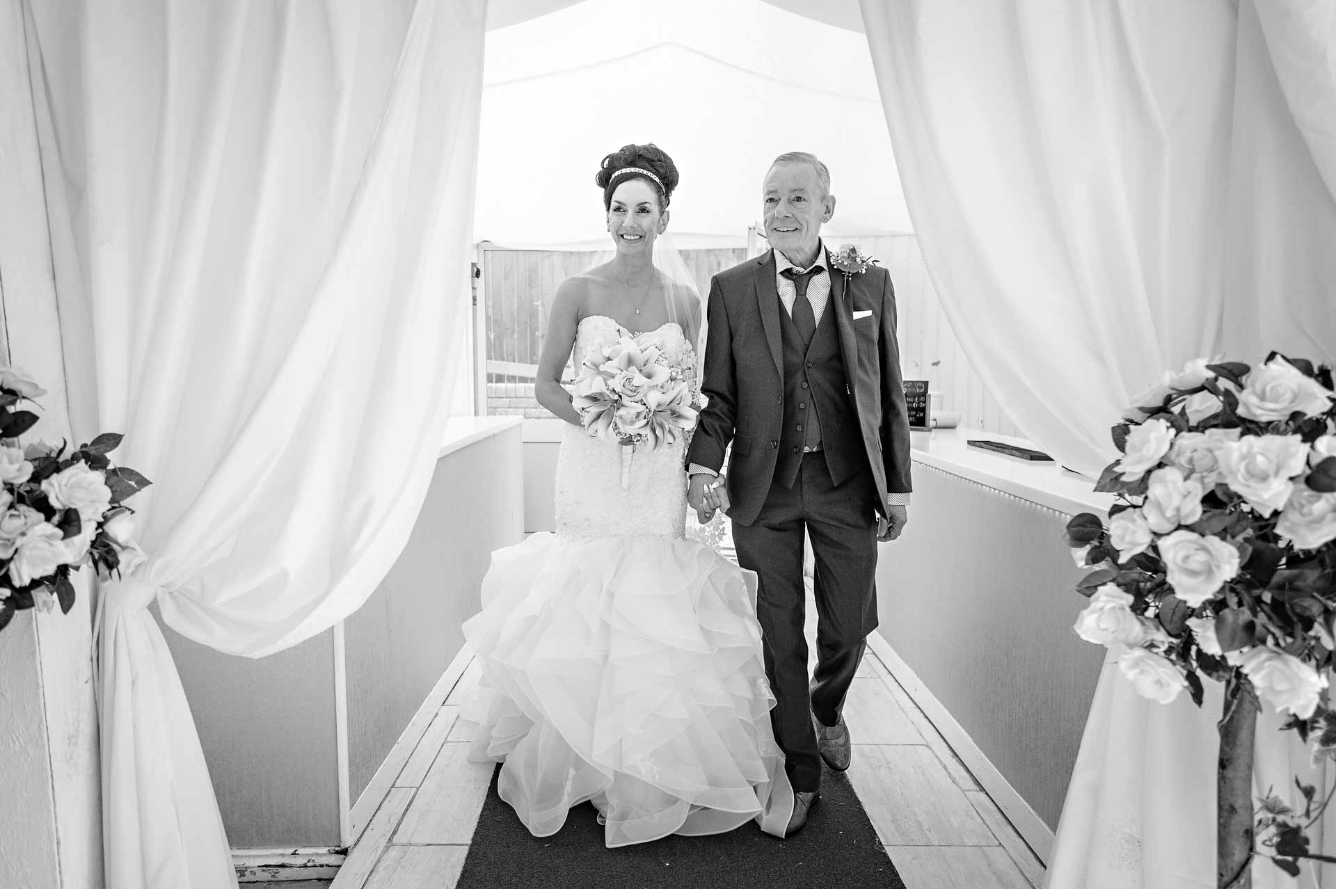 The bride and her father entering the Marquee at Ridgeway Golf Club