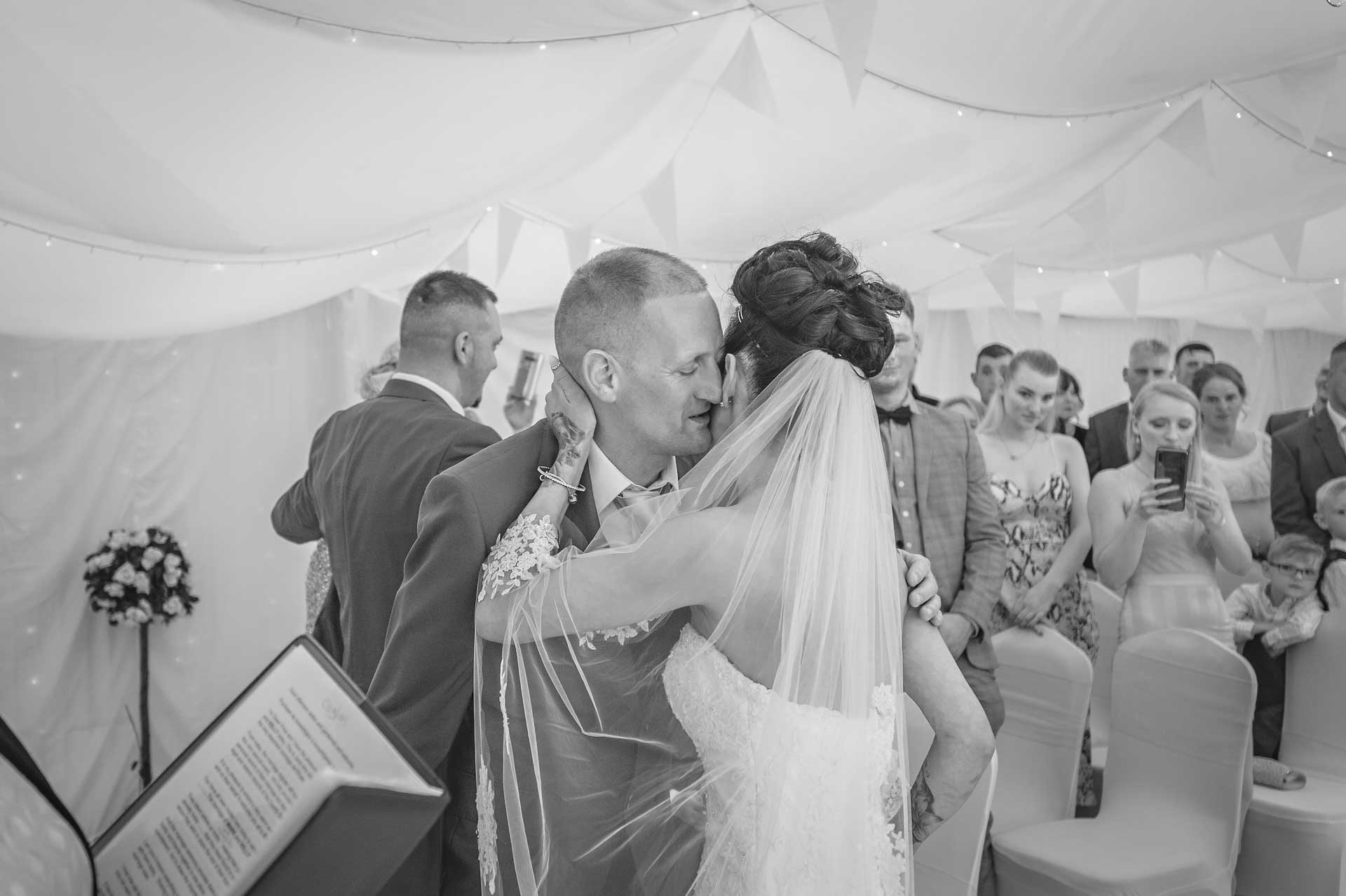 The bride and groom hugging at the start of their wedding at Marquee at Ridgeway Golf Club in Caerphilly