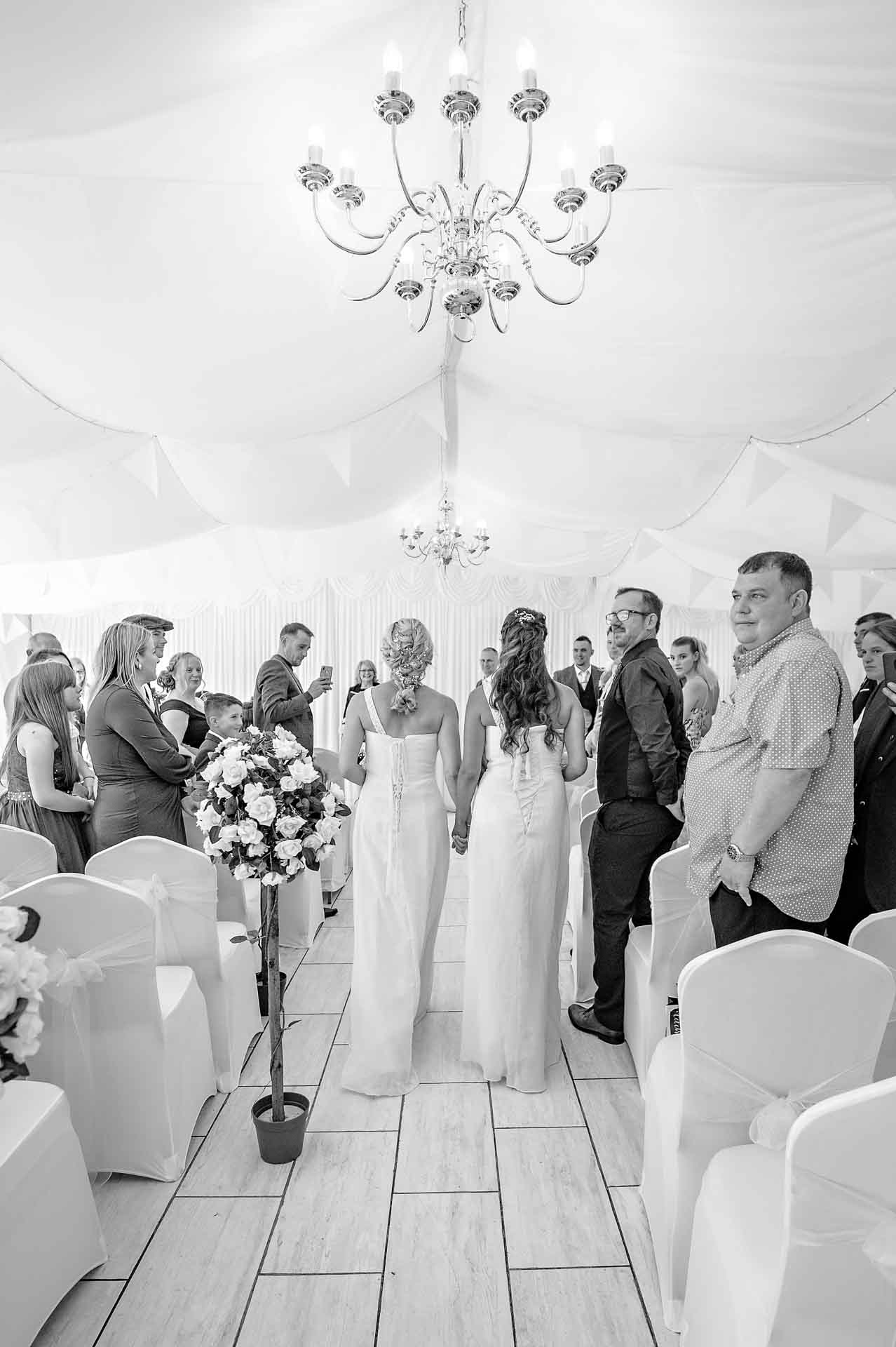 Back shot of bridesmaids walking down the aisle at Marquee at Ridgeway Golf Club