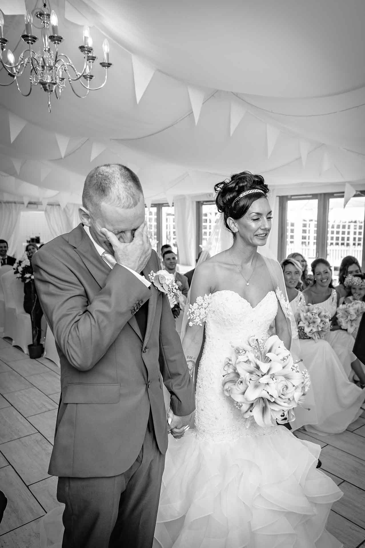 The groom rubs his eyes in emotion at wedding in Caerphilly