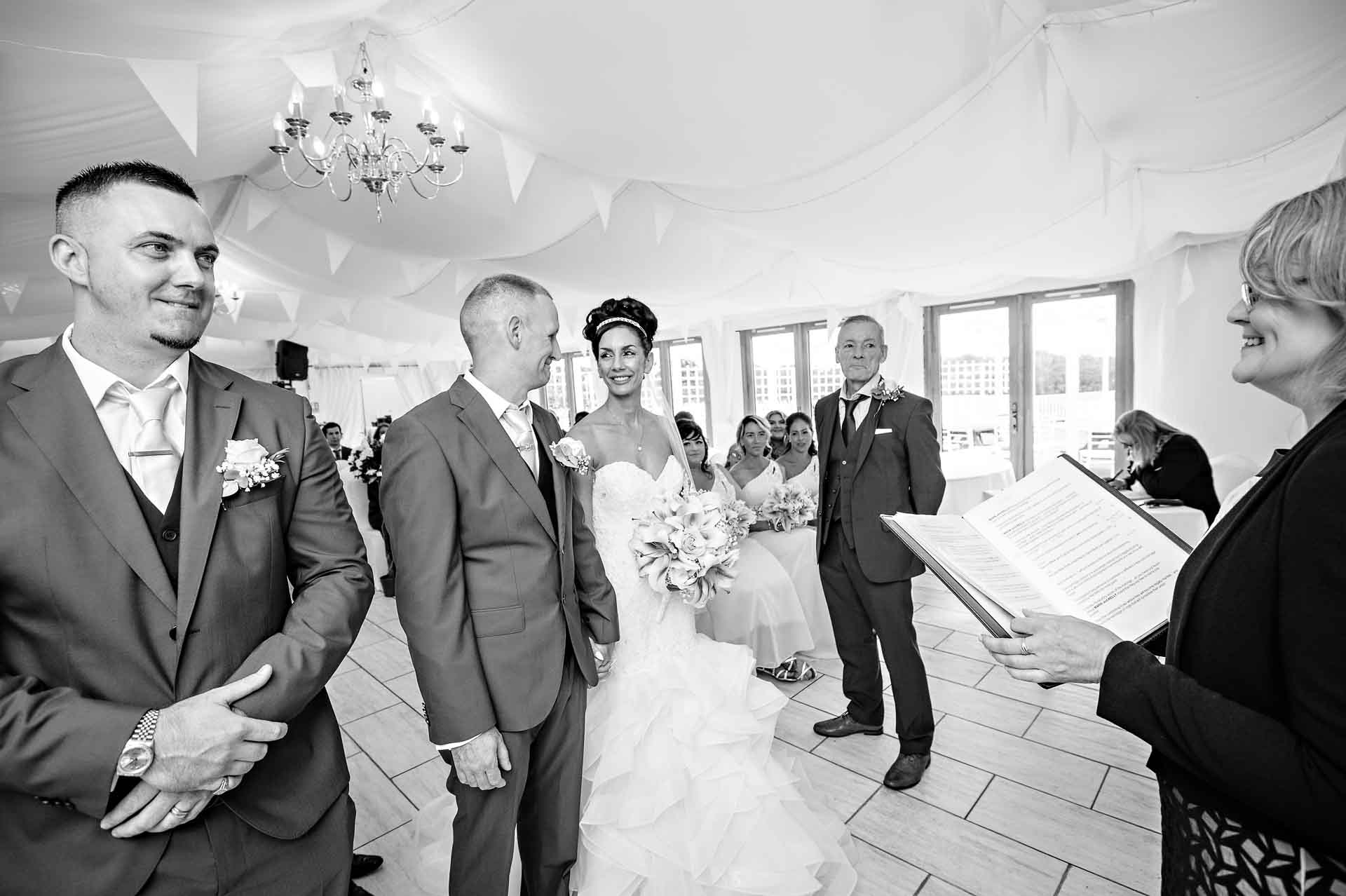 The bride and groom look at each other in the Marquee at the Ridgeway Golf Clud, Caerphilly during their wedding ceremony