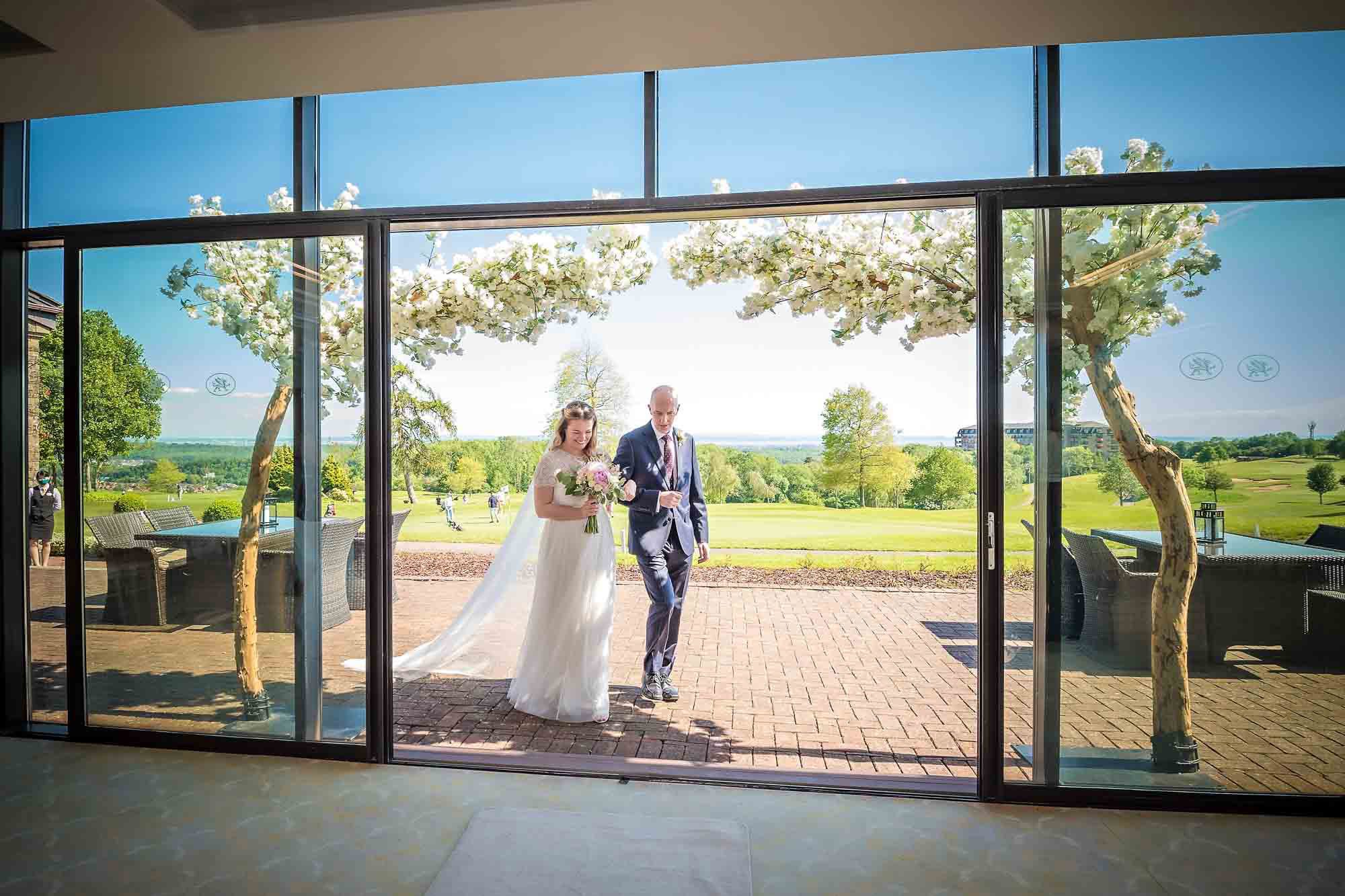 Bride and her father entering the Via Julia Suite for her wedding ceremony at Celtic Manor Resort