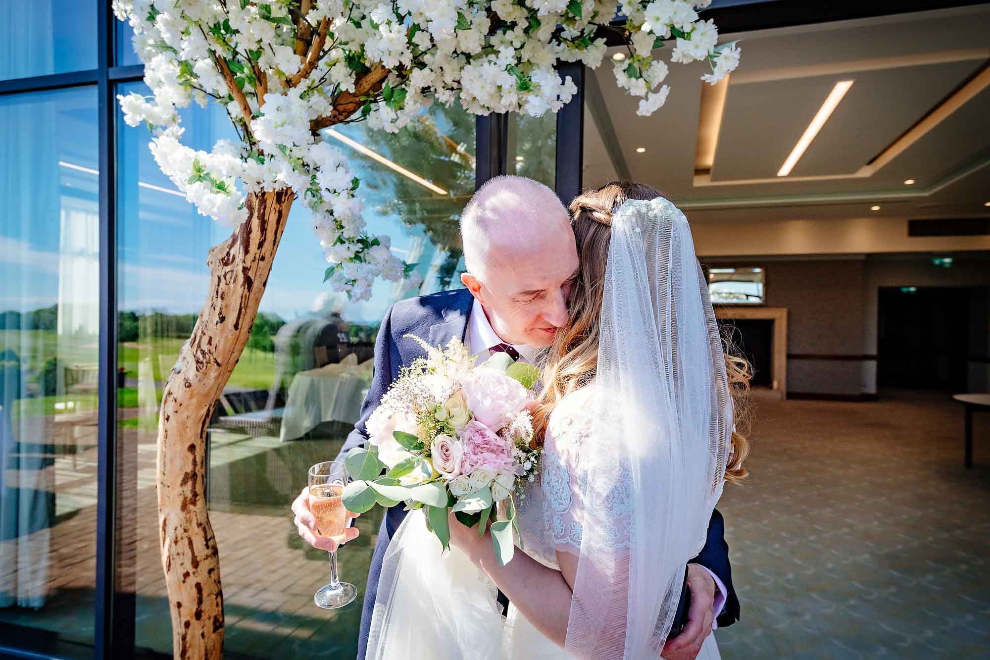 Bride and father hug outside Via Julia Suite, Celtic Manor Resort