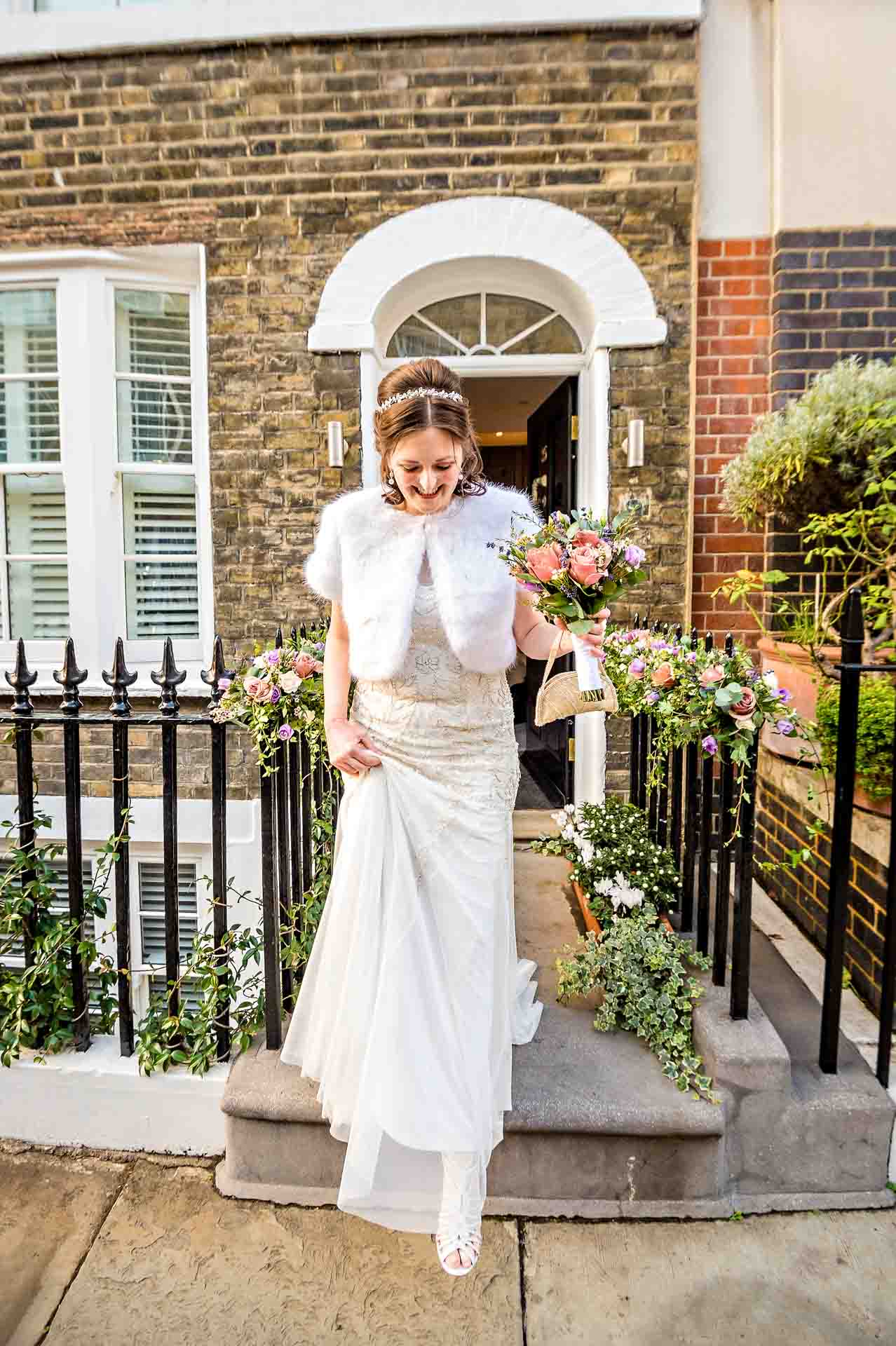 bride in wedding dress leaving terraced house in London